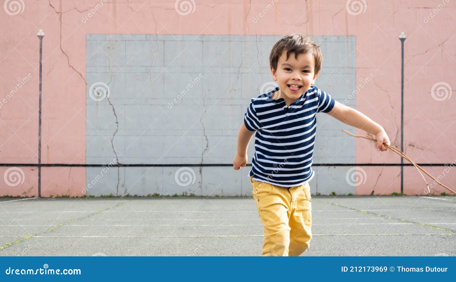 little boy running towards camera on basque pelota court