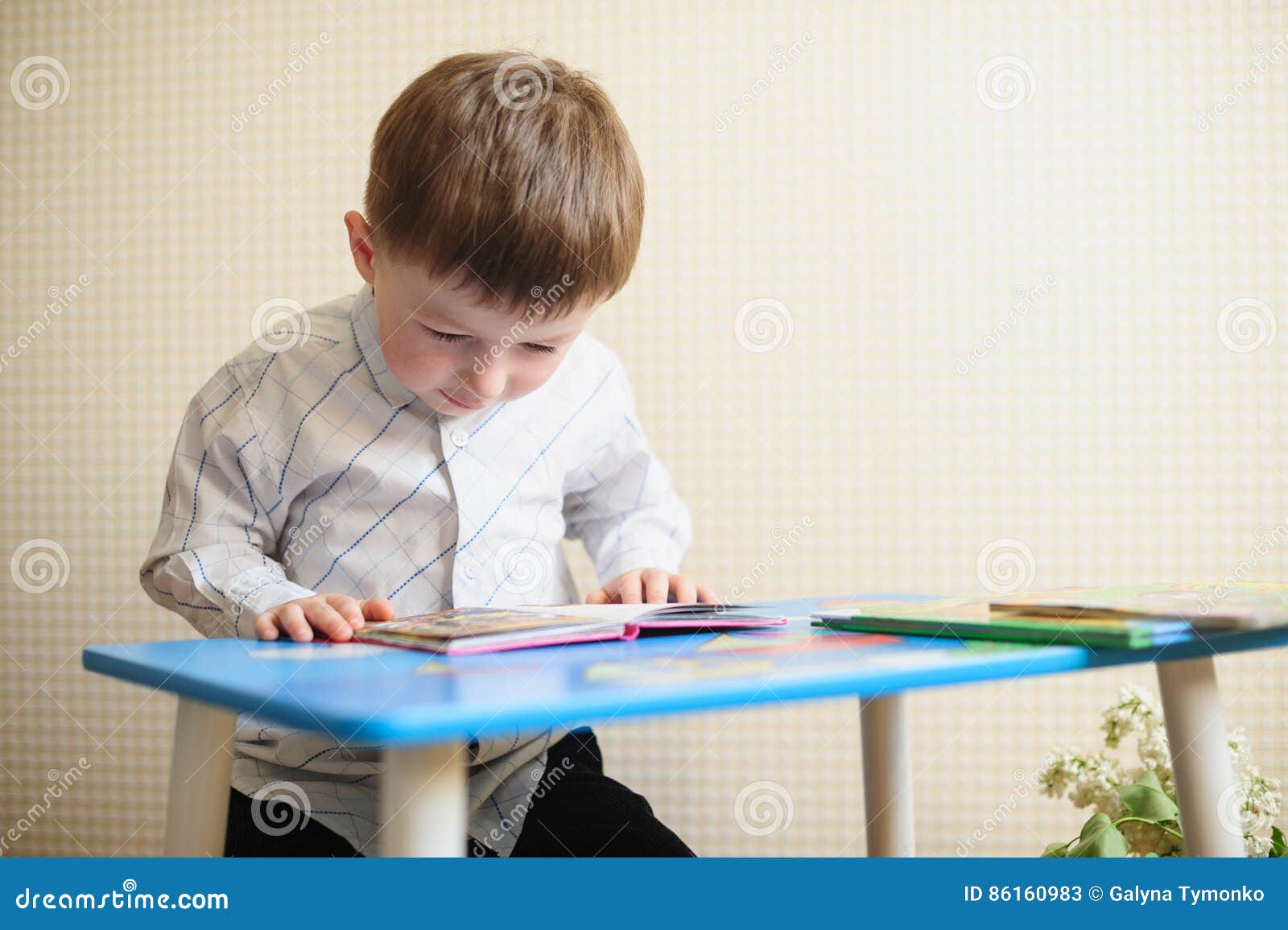 Little Boy Sitting at the Desk and Reading a Book Stock Image Image