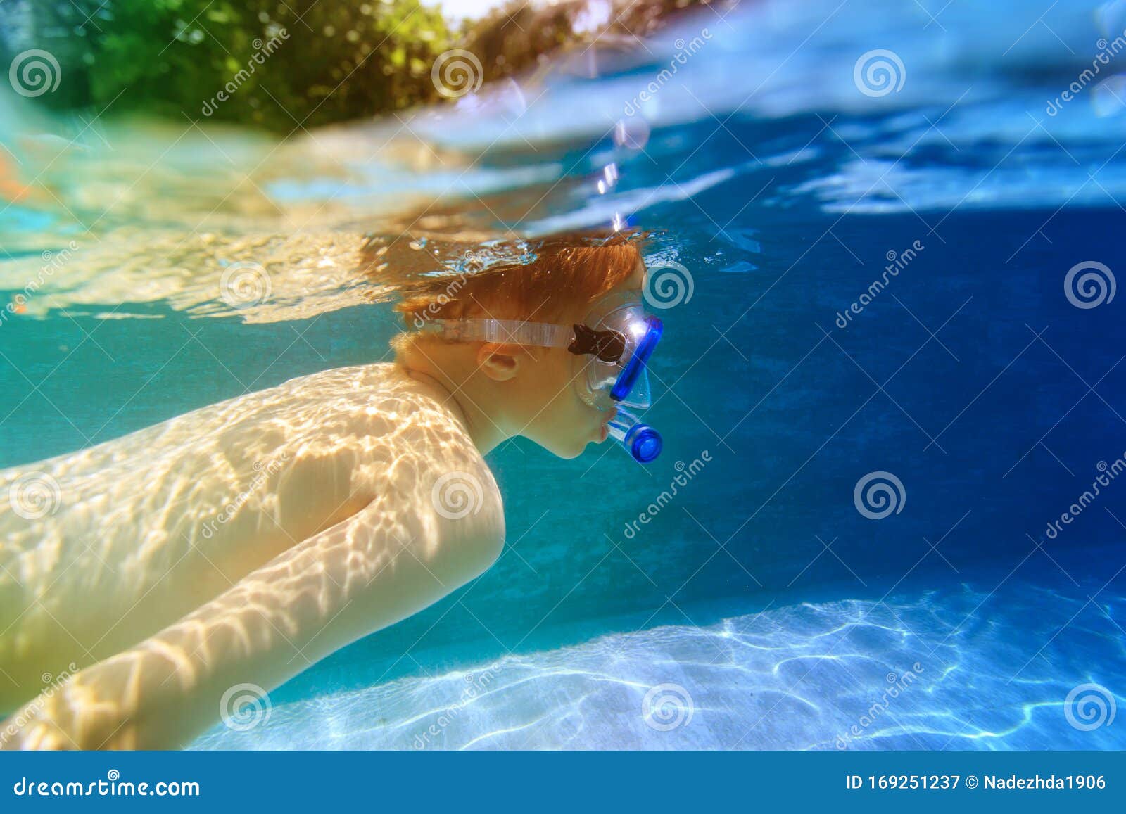 Boy In Diving Mask Swim Underwater In The Swimming Pool 