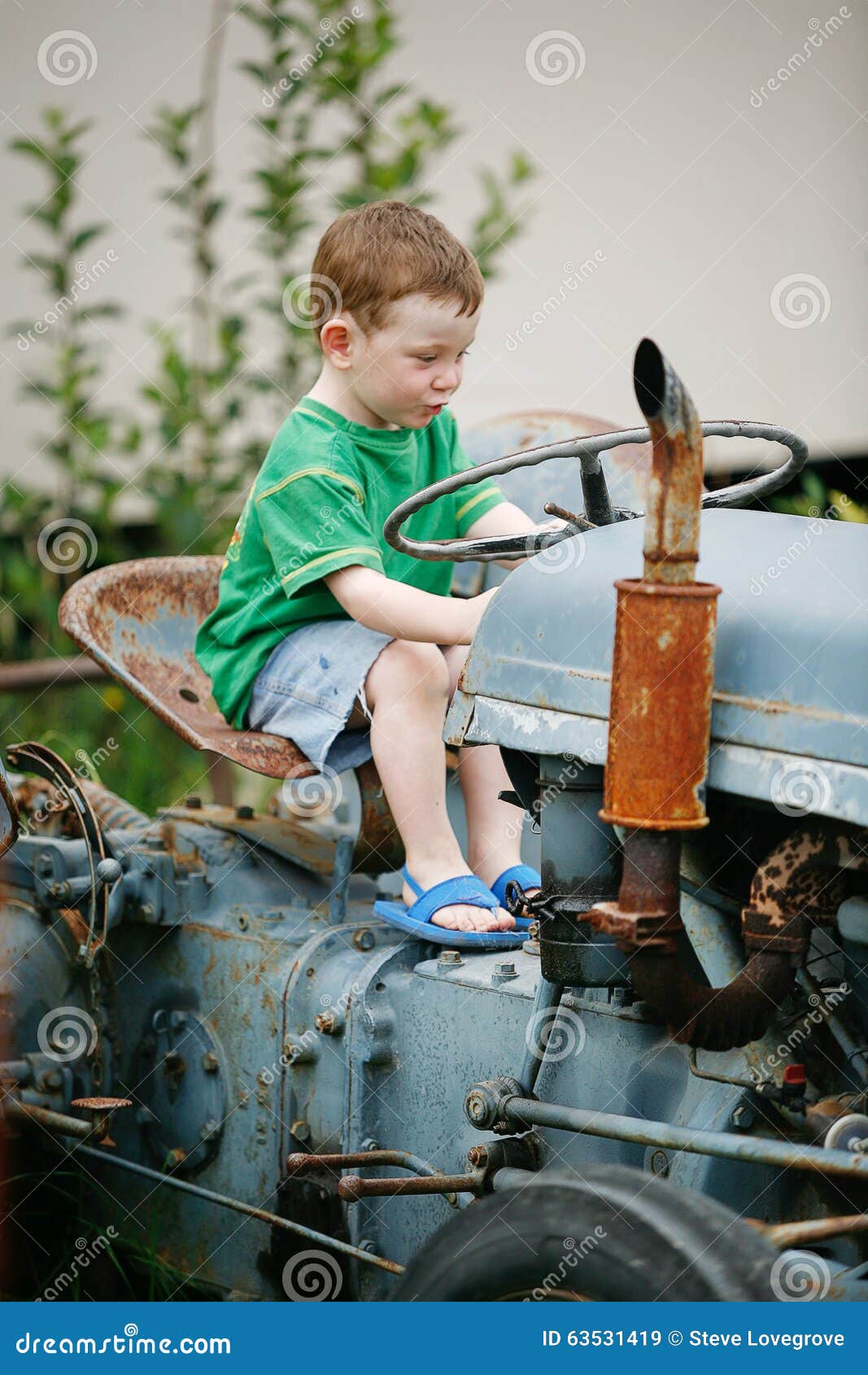 Little boy on a tractor stock image. Image of industrial 63531419