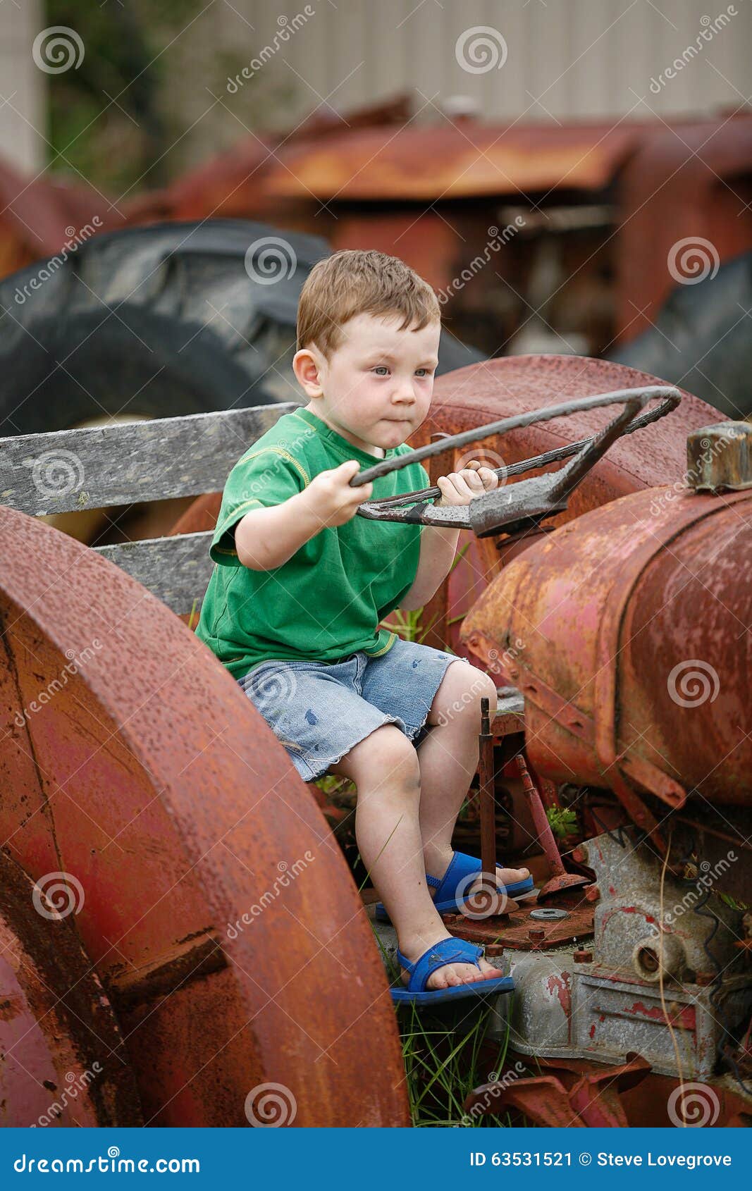 Little boy on a tractor stock image. Image of derelict 63531521