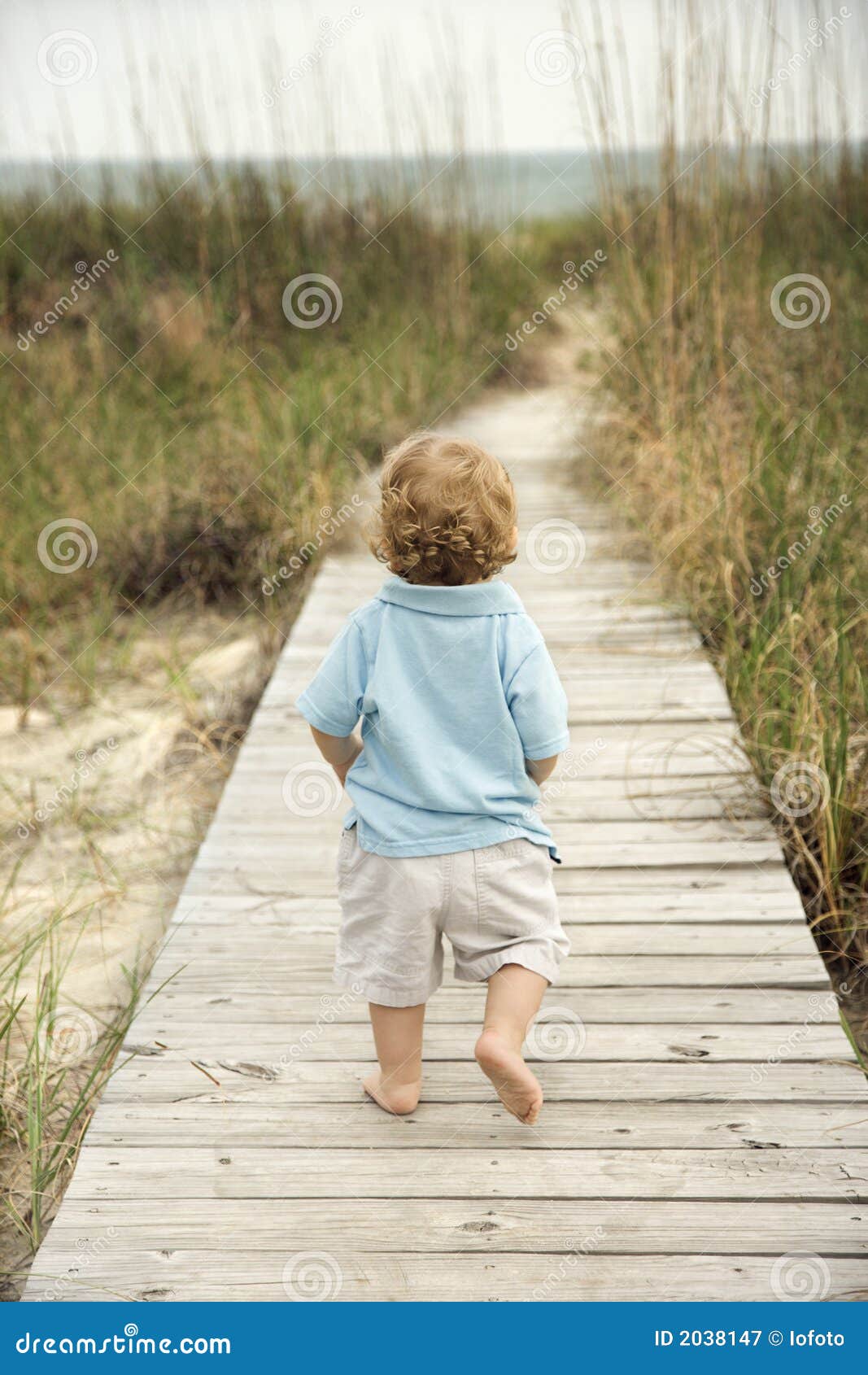 Little Boy Walking Down Beach Walkway. Royalty Free Stock Photography