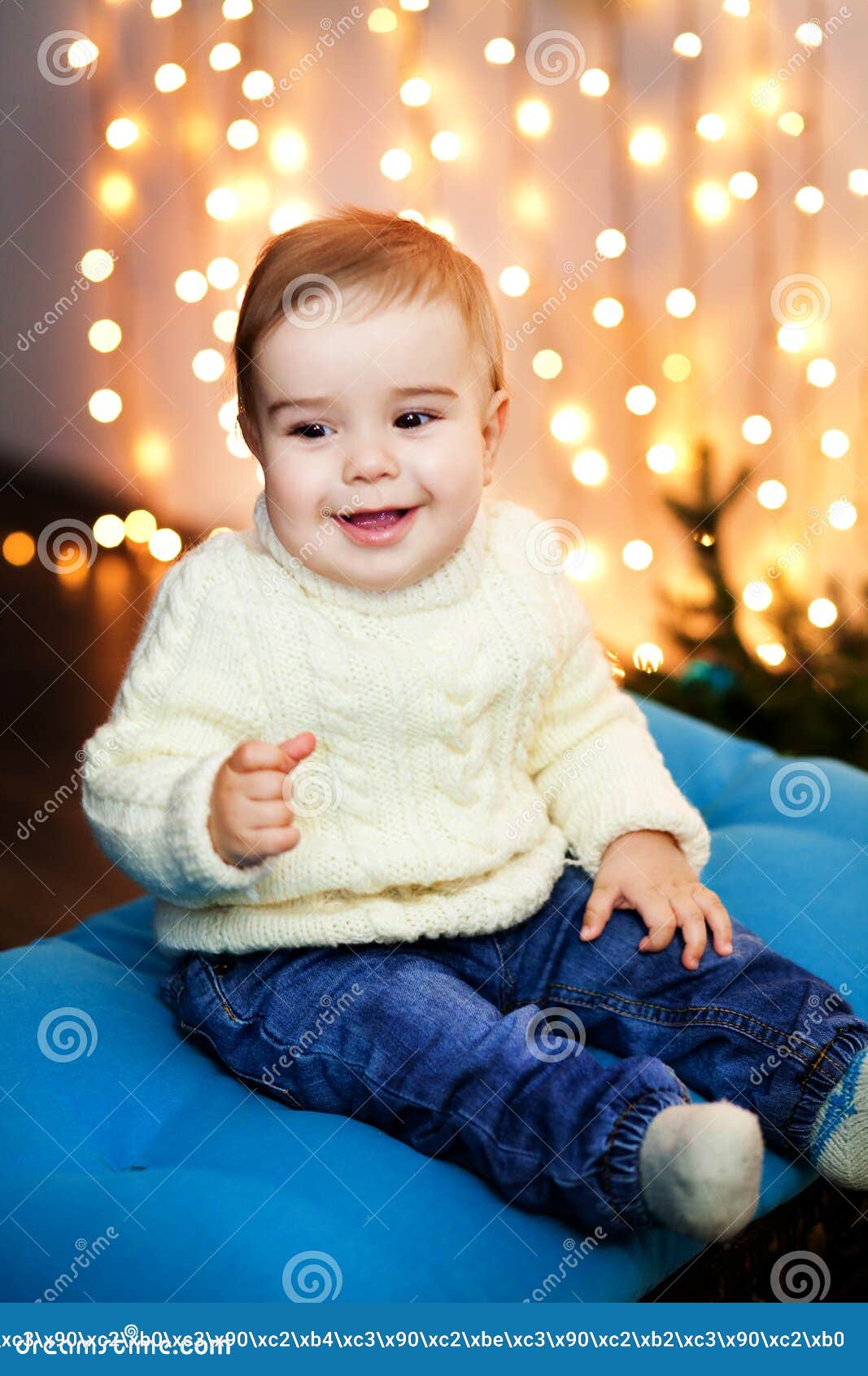 Little Boy in White Sweater Sit in the Rain of Lights and Laugh Stock