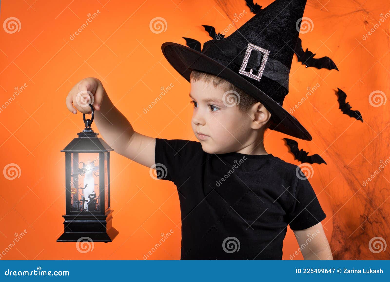 A Little Boy 4 Years Old in a Witch Costume in a Black Hat Holds a ...