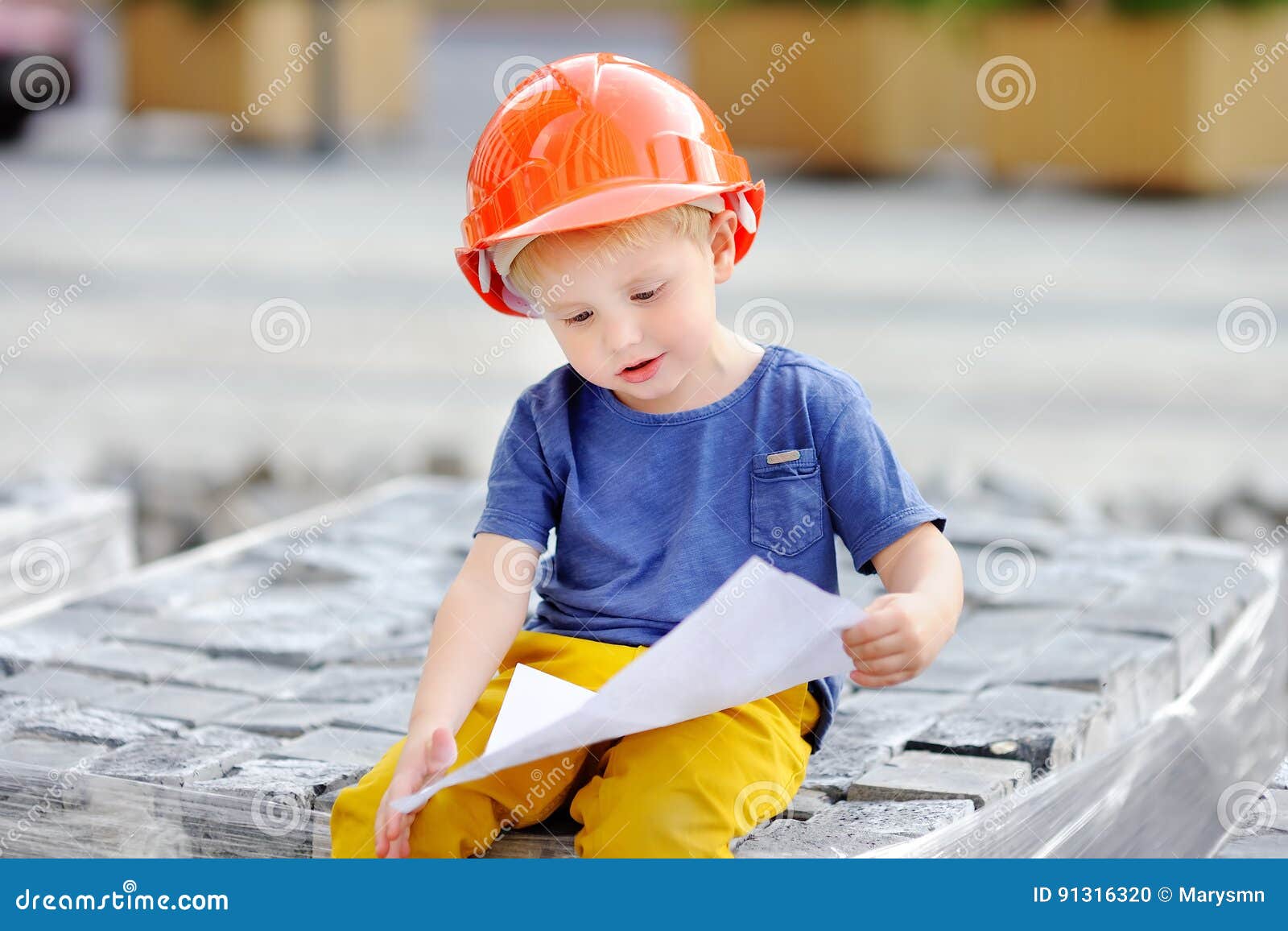 Little Builder in Hardhats Reading Construction Drawing Stock Photo