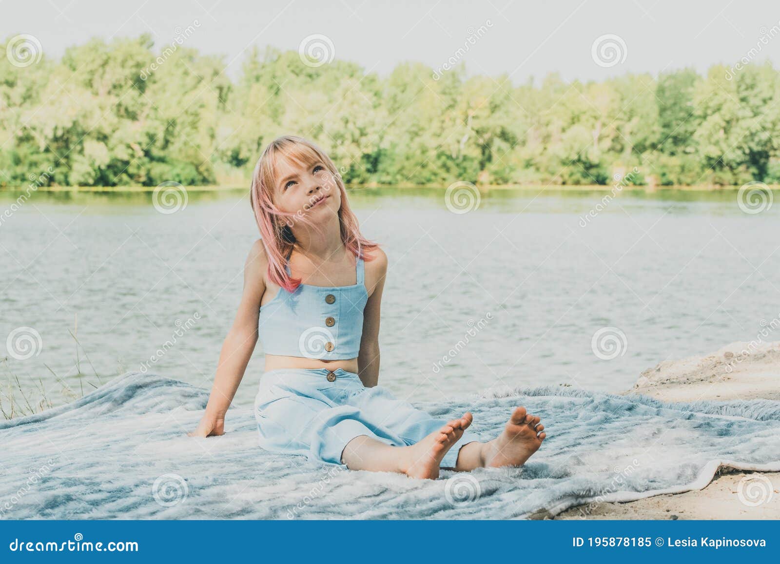Little Charming Girl Sitting Near the River. Little Girl Near the River ...