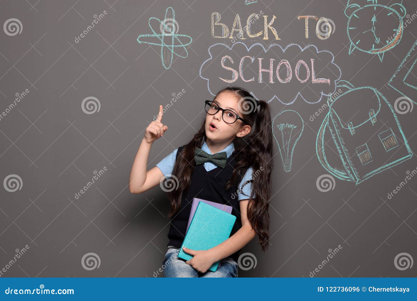 little child in uniform near drawings with text back to school