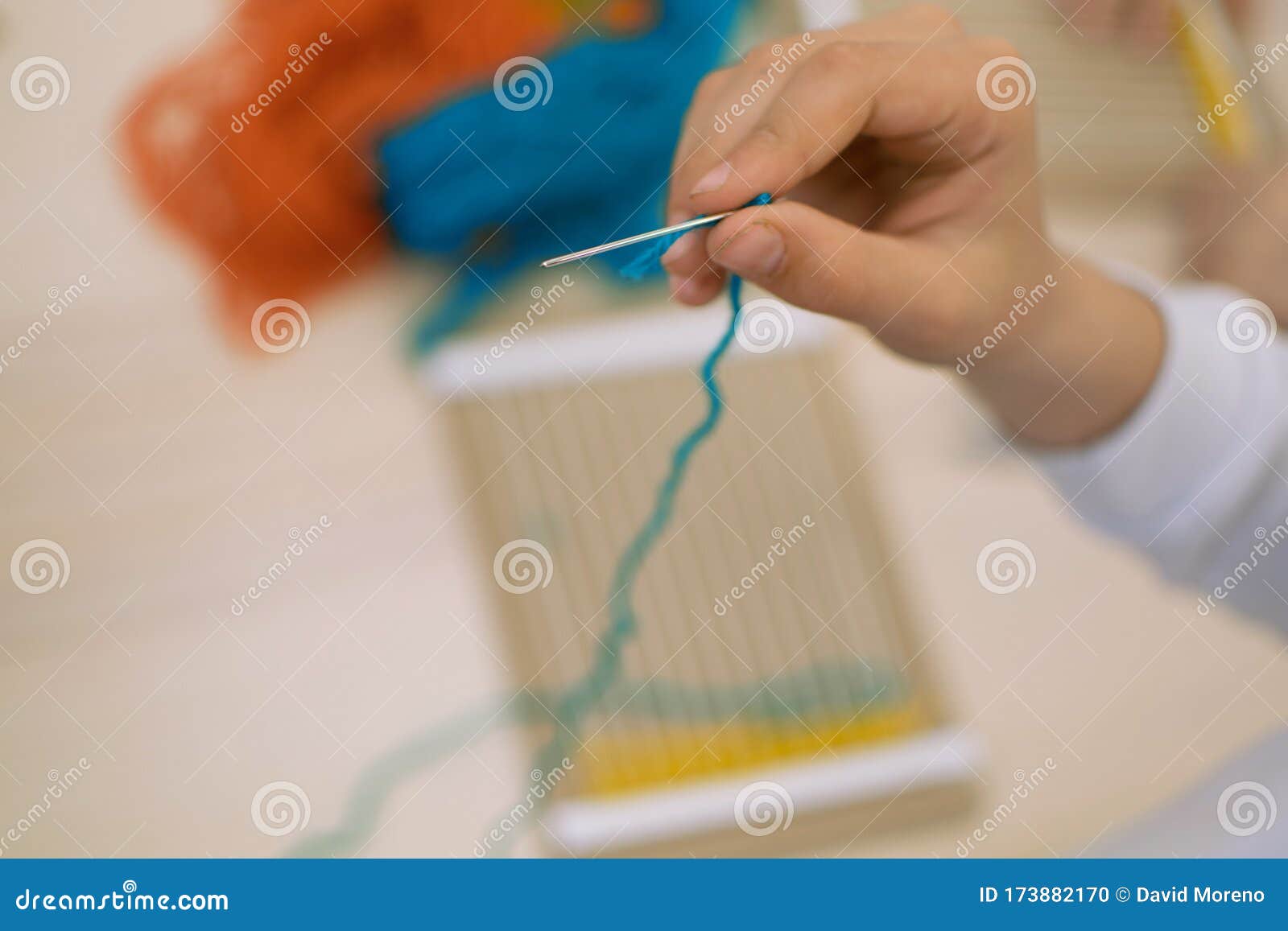 little children hands weaving loom in art theraphy class at school. education concept. telar weave looom