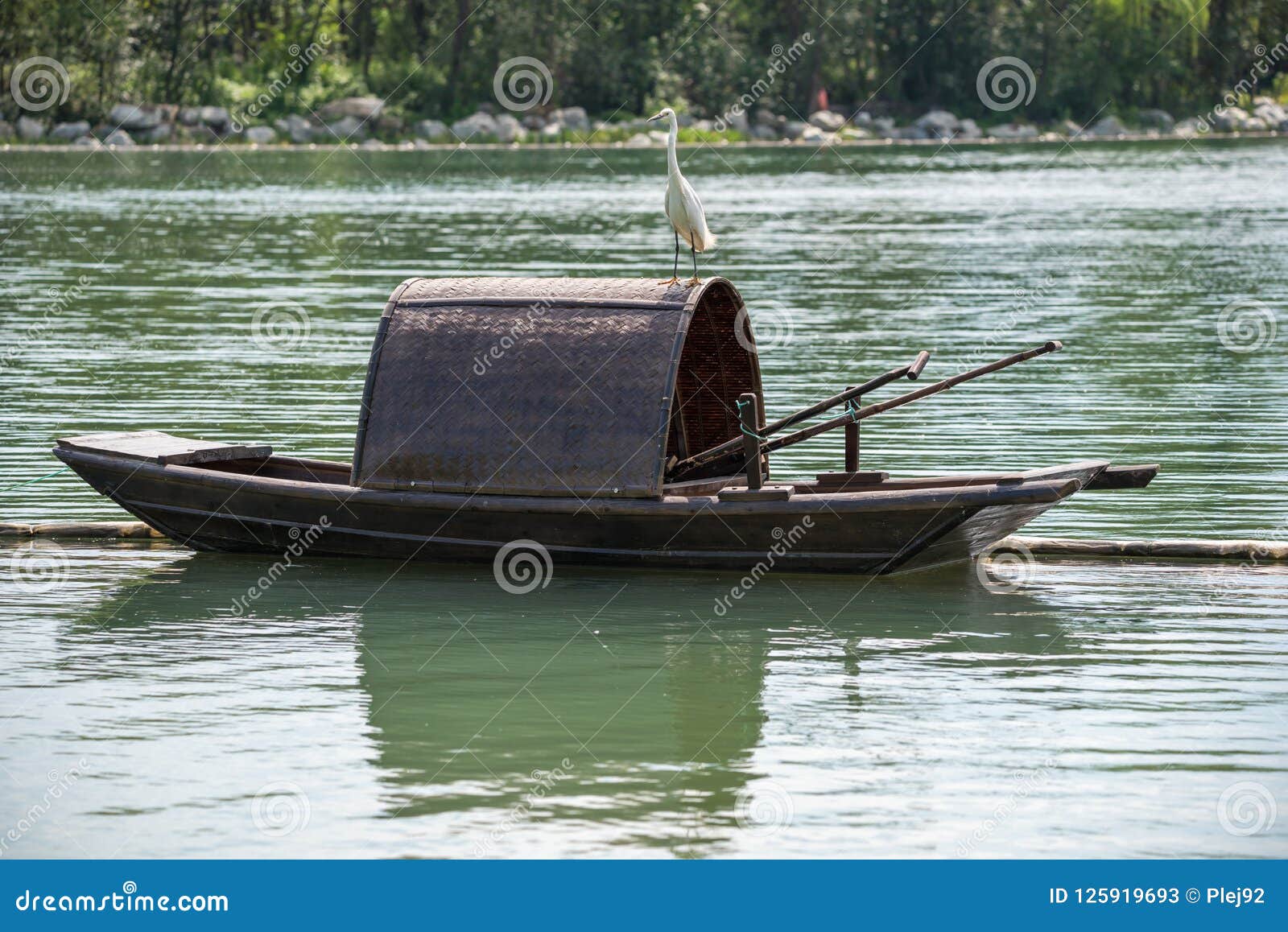 Little egret on a chinese traditional fishing boat on a lake stock