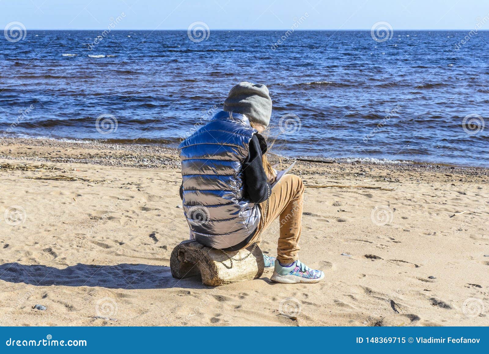 Little Girl on the Beach, Against the Background of Stones, Sand ...