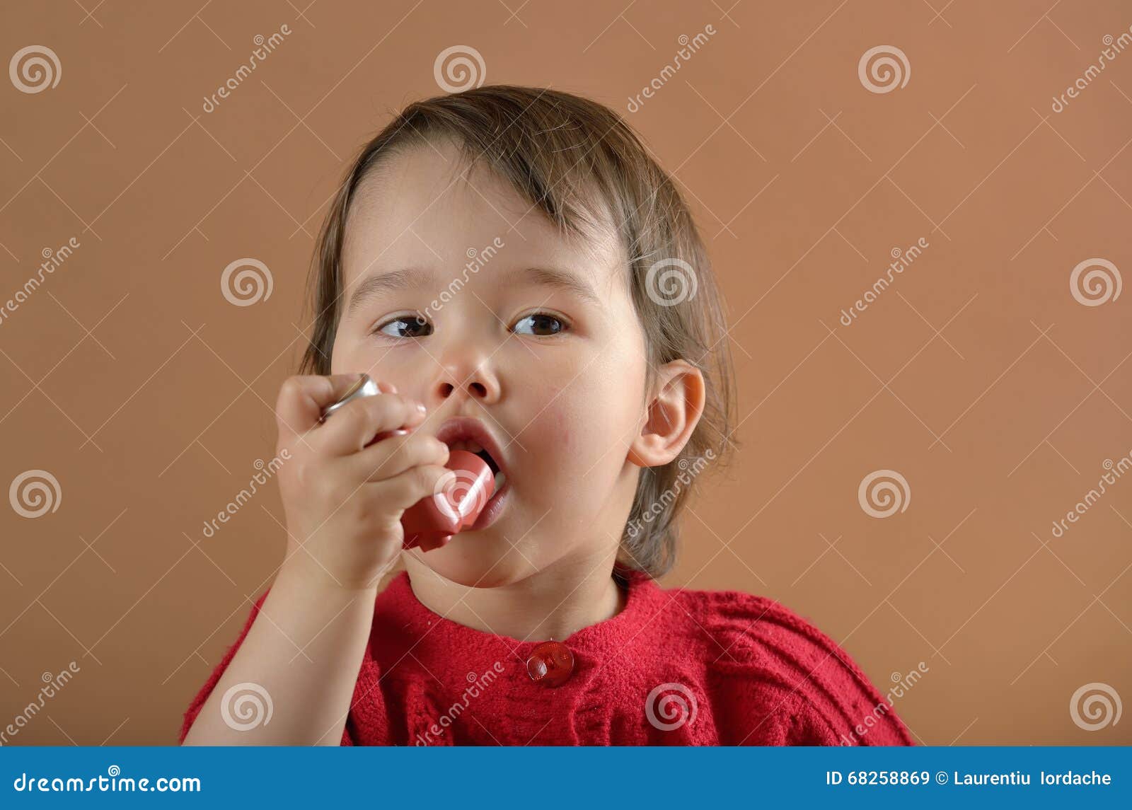little girl breathing asthmatic medicine inhaler
