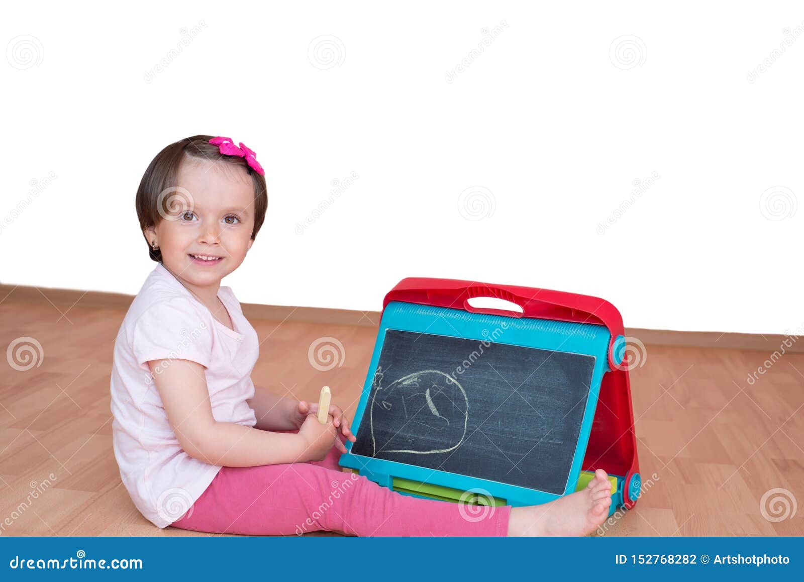 Happy Little Toddler Girl With Chalk Desk In Hands 