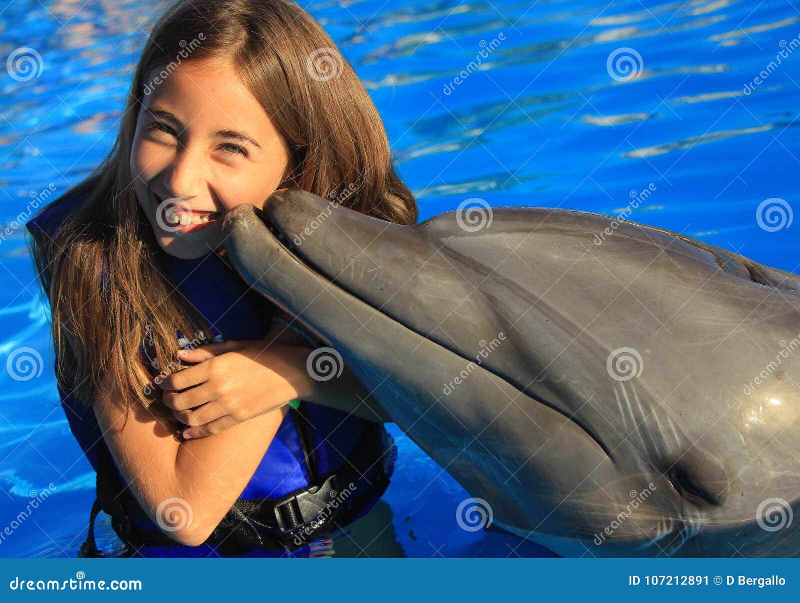 little girl children kissing a gorgeous dolphin flipper smiling face happy kid swim bottle nose dolphins