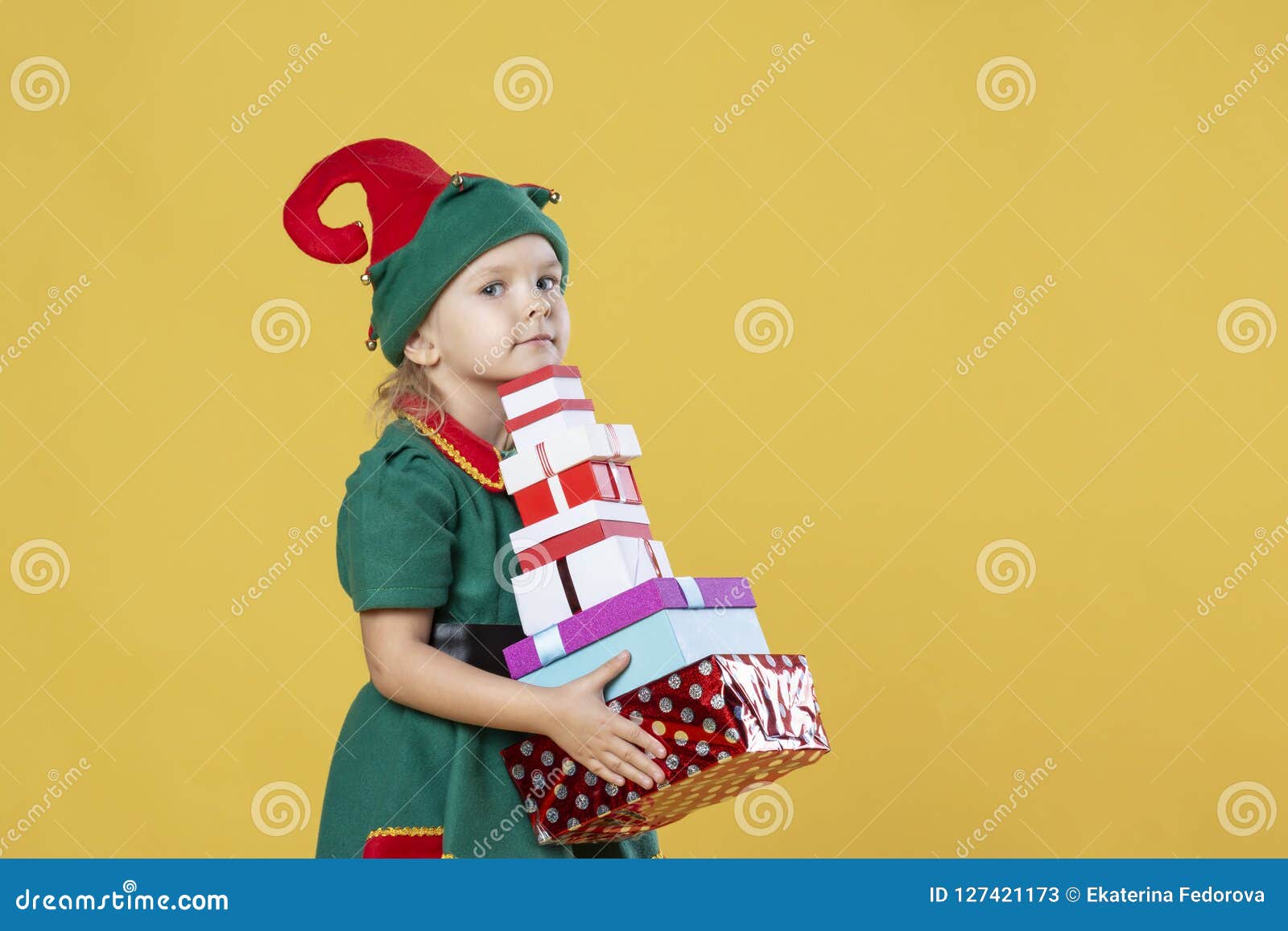 Little Girl In A Christmas Elf Costume On A Yellow