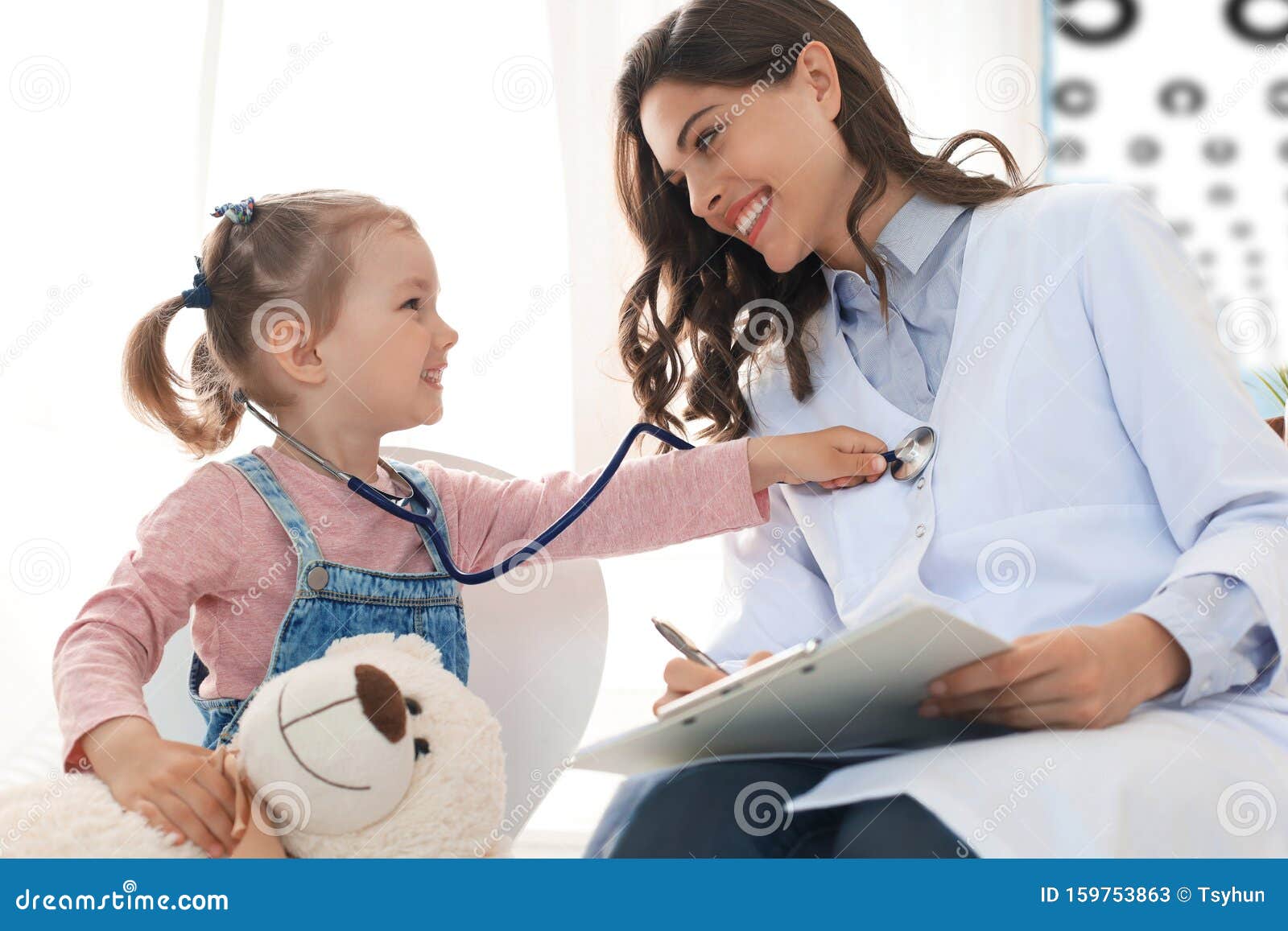 little girl at the doctor for a checkup. child auscultate the heartbeat of the doctor.