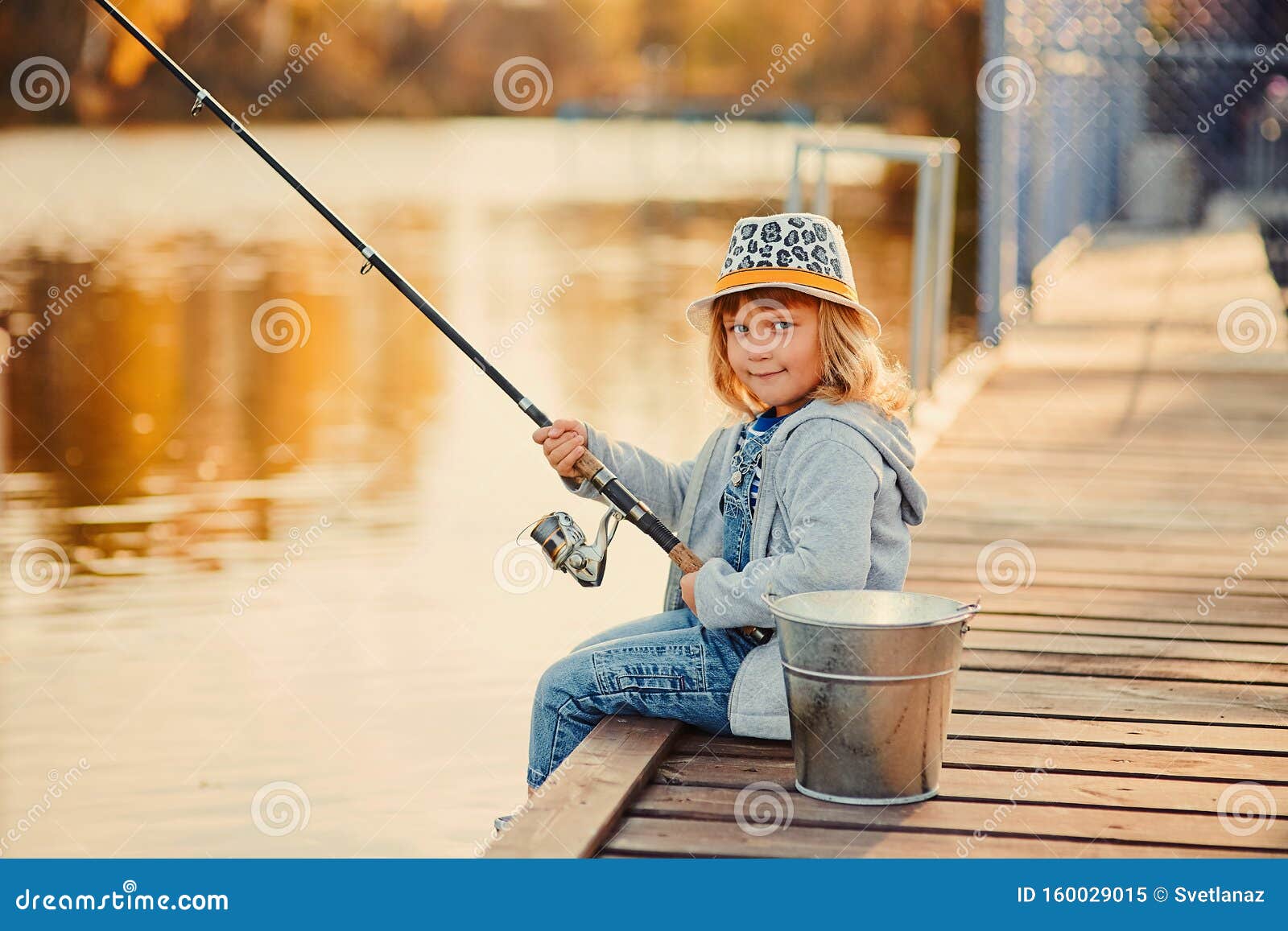 A Little Girl Fishing with a Fishing Rod from a Pontoon or Pier on