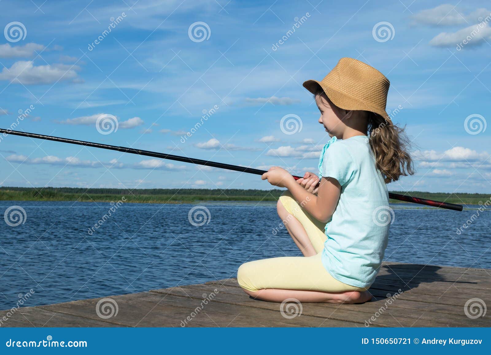 Little Girl with a Hat is Fishing on a Lake on a Sunny Day Stock