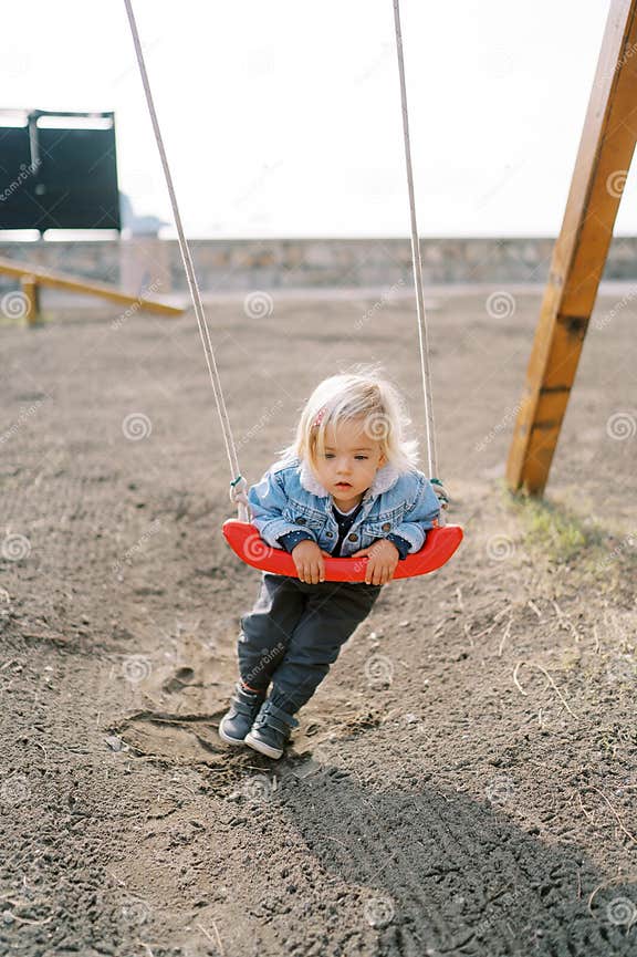 Little Girl on Her Stomach Swings on a Rope Swing Stock Photo Image