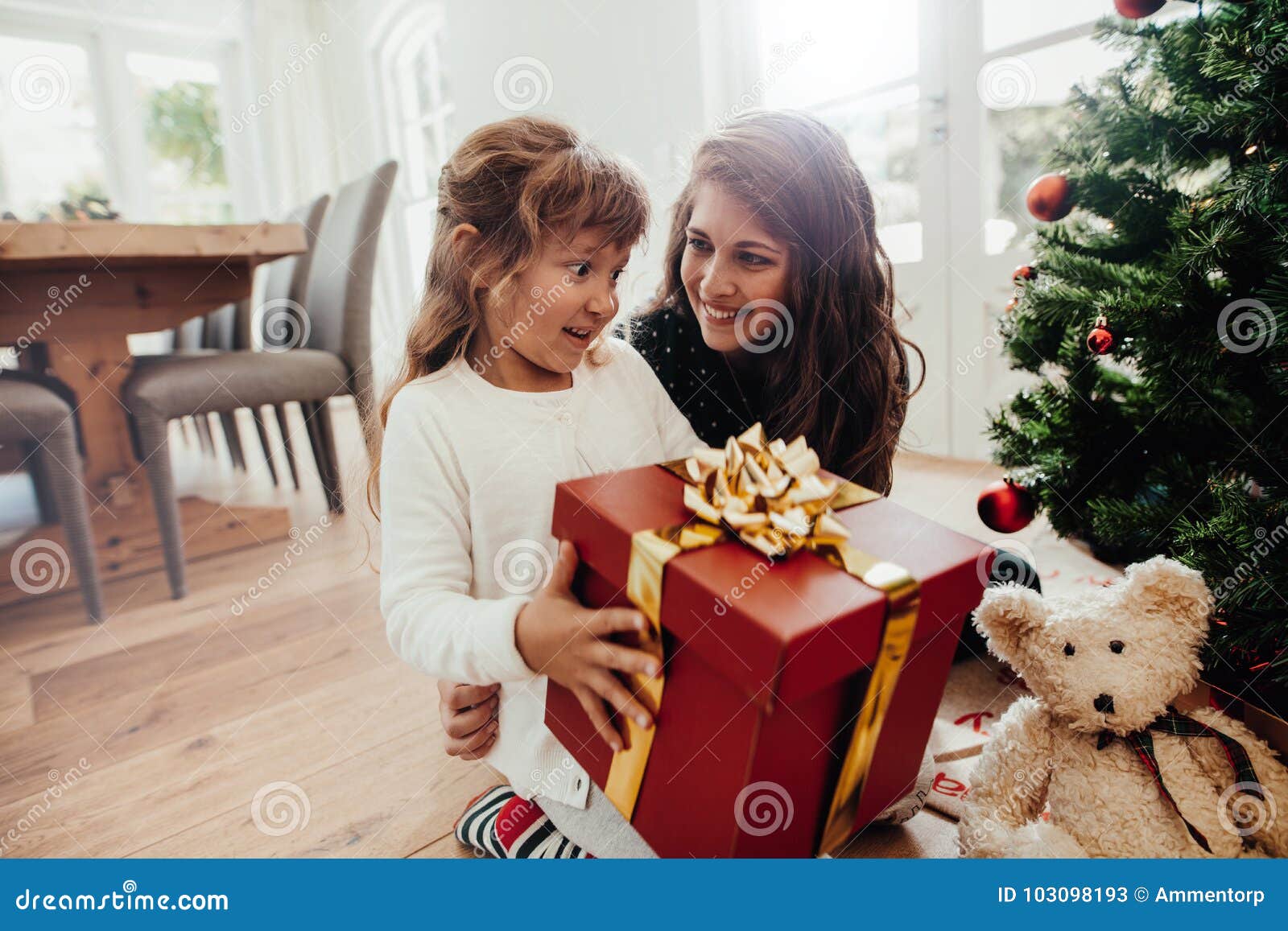 https://thumbs.dreamstime.com/z/little-girl-holding-christmas-gift-sitting-her-mother-happy-family-gifts-near-tree-home-giving-to-child-103098193.jpg