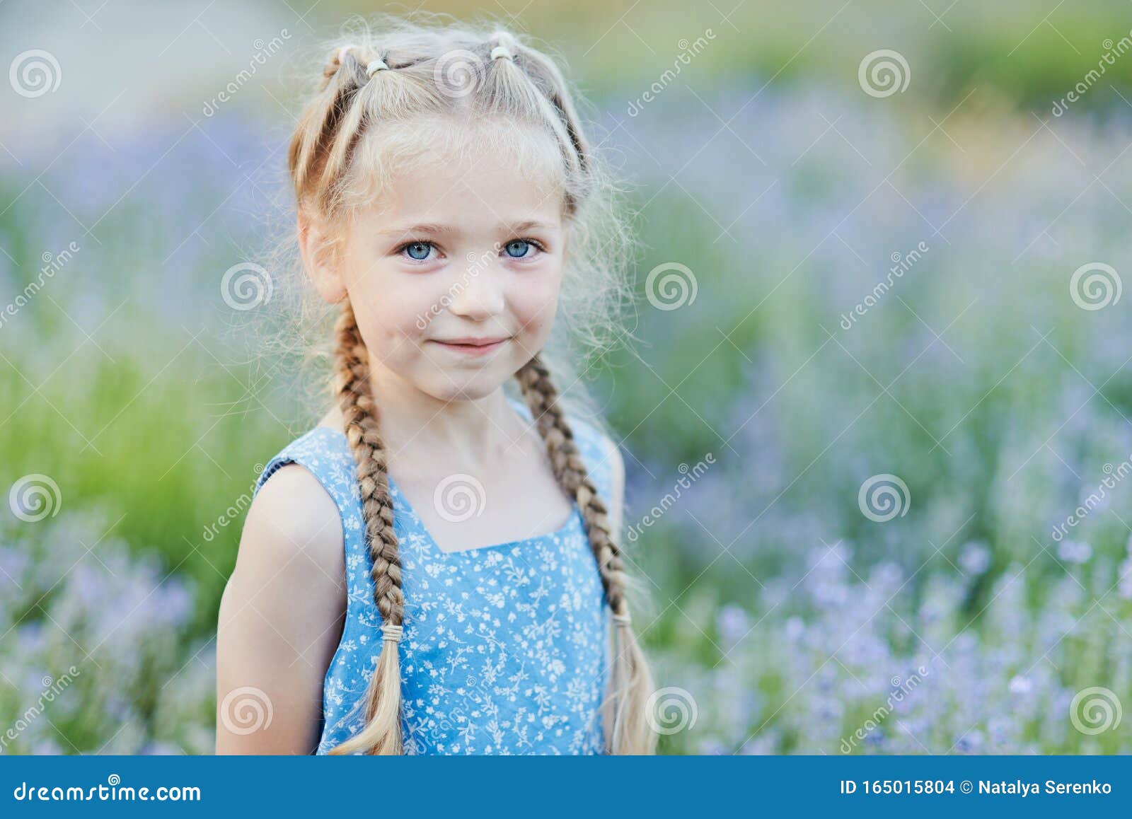 little girl in lavender field. kids fantasy. smiling girl sniffing flowers in summer purple lavender field