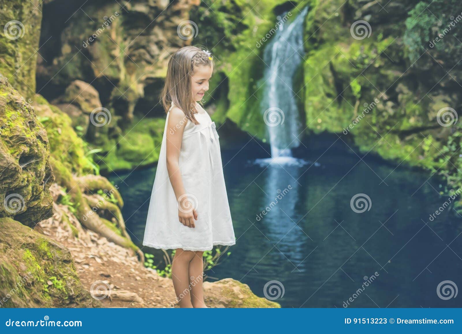little girl looks at the smiling water by a river