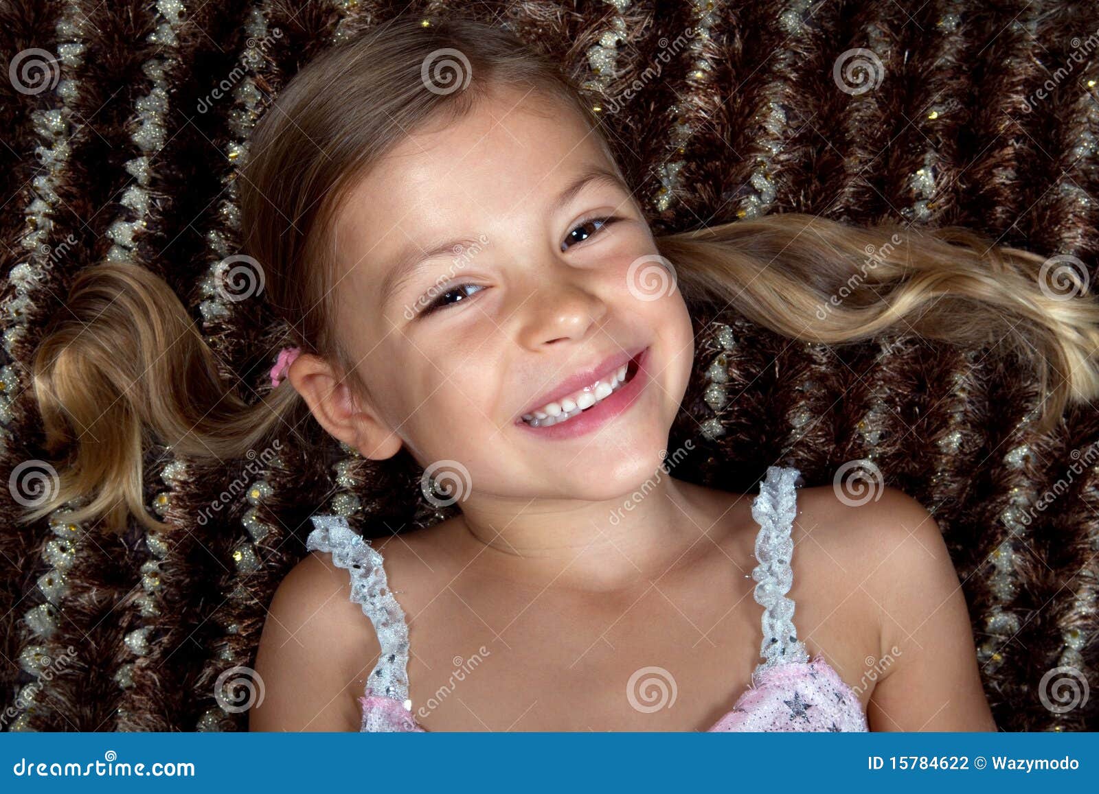 little girl lying down on a rug and smiling