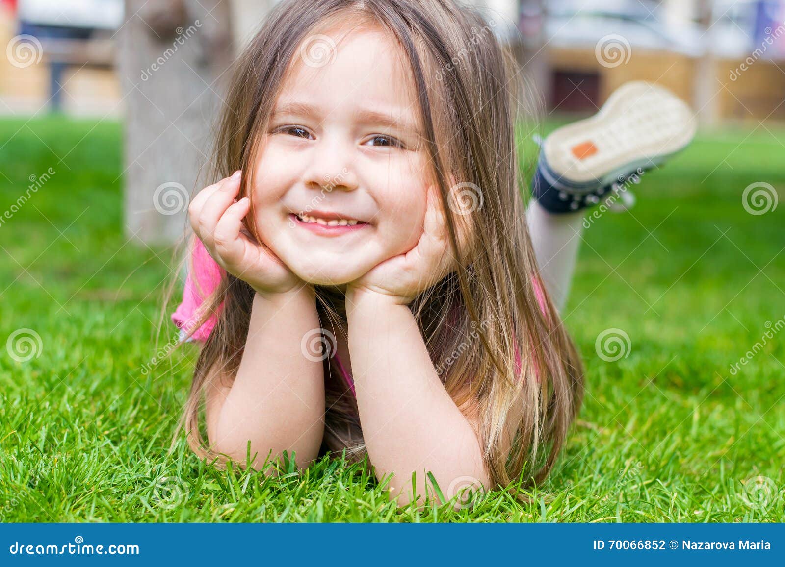 Little girl lying on grass and smiling