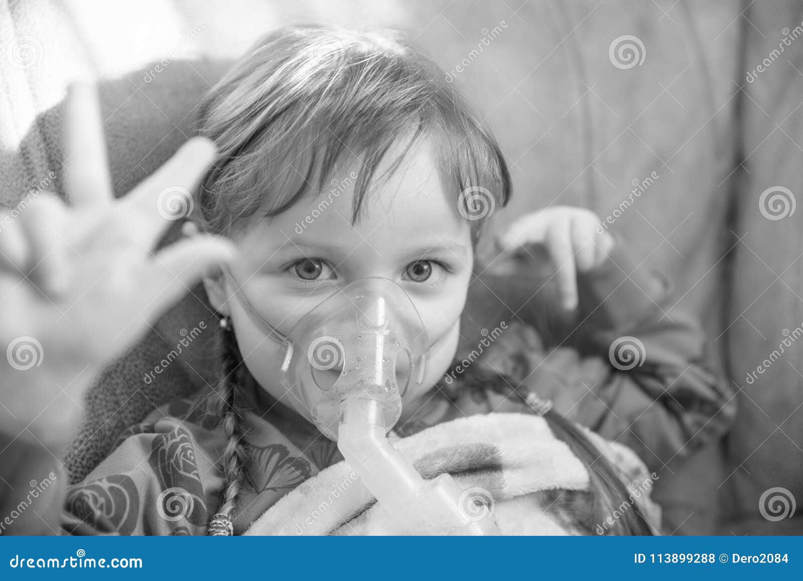 little girl in a mask, treatments respiratory tract with a nebulizer at home, colorless