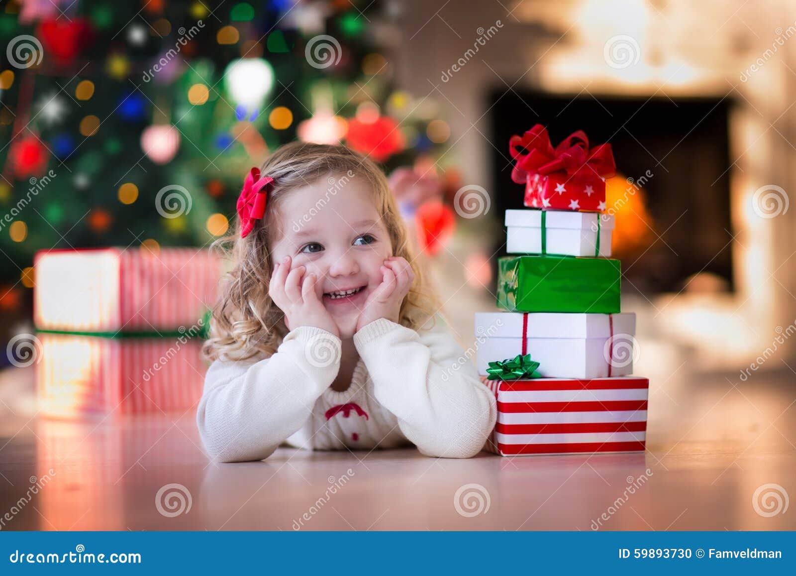Little Girl Opening Christmas Presents at Fire Place Stock Photo