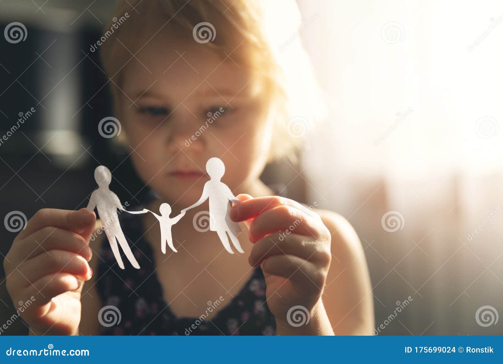 little girl with paper family in hands. concept of divorce, custody and child abuse