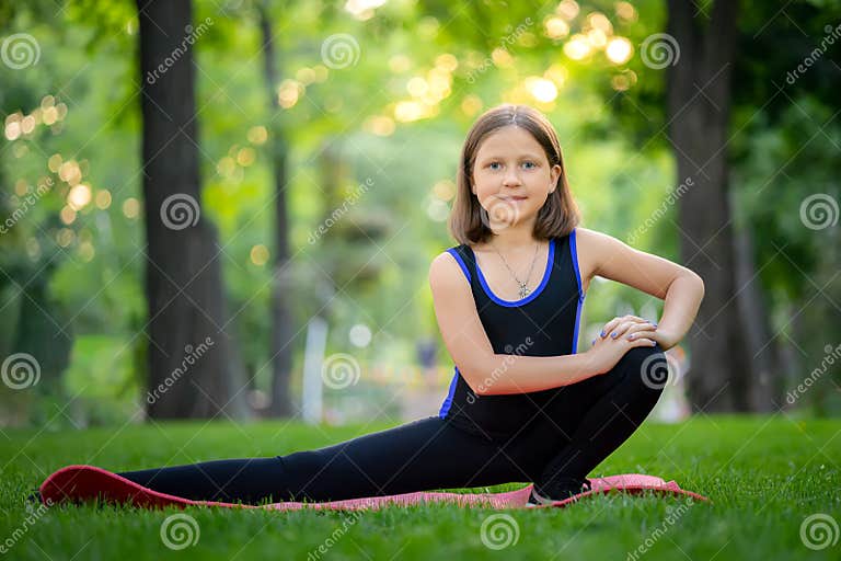 A Little Girl in the Park Performs Stretching, Stretching Her Squatting ...
