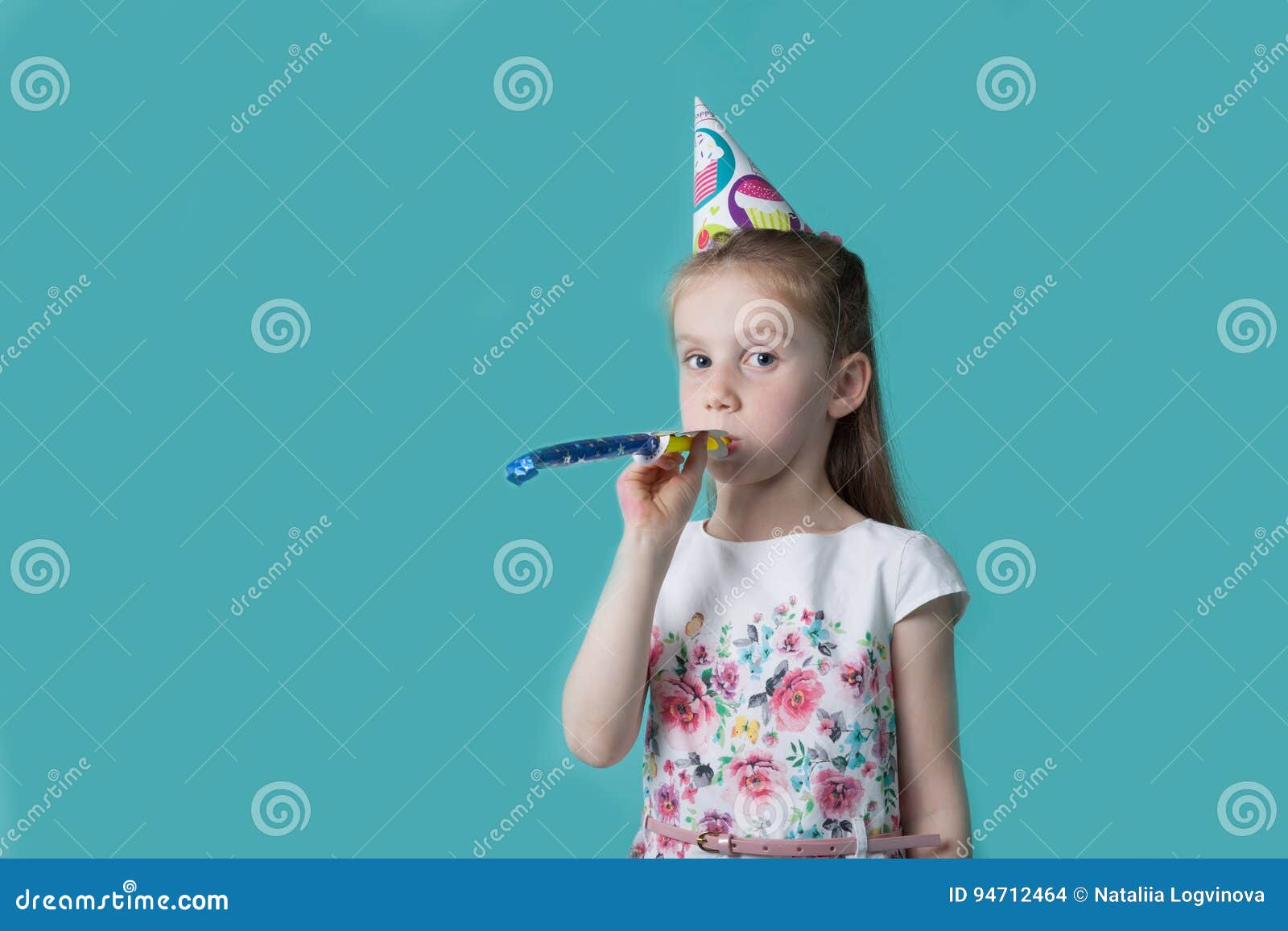 Little Girl with Party Hat on Mint Background. Birthday Girl Blowing ...