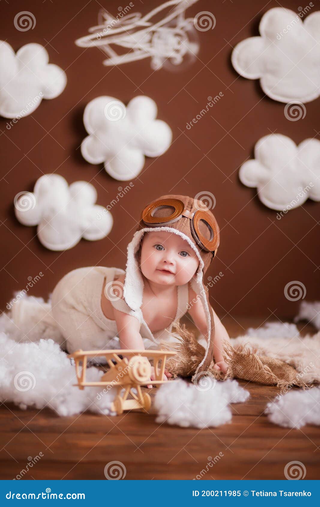 Little Girl in a Pink White Suit and a Pilot`s Hat with White Clouds ...