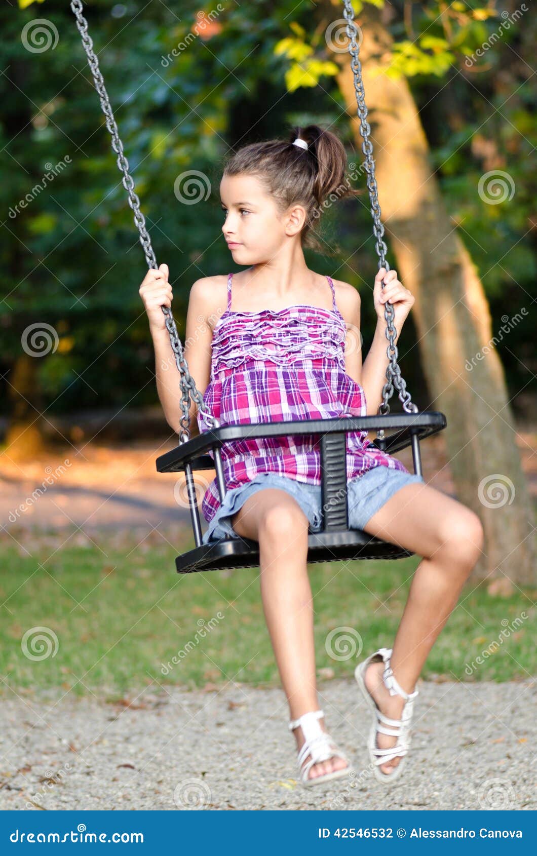 little girl playing on the swing