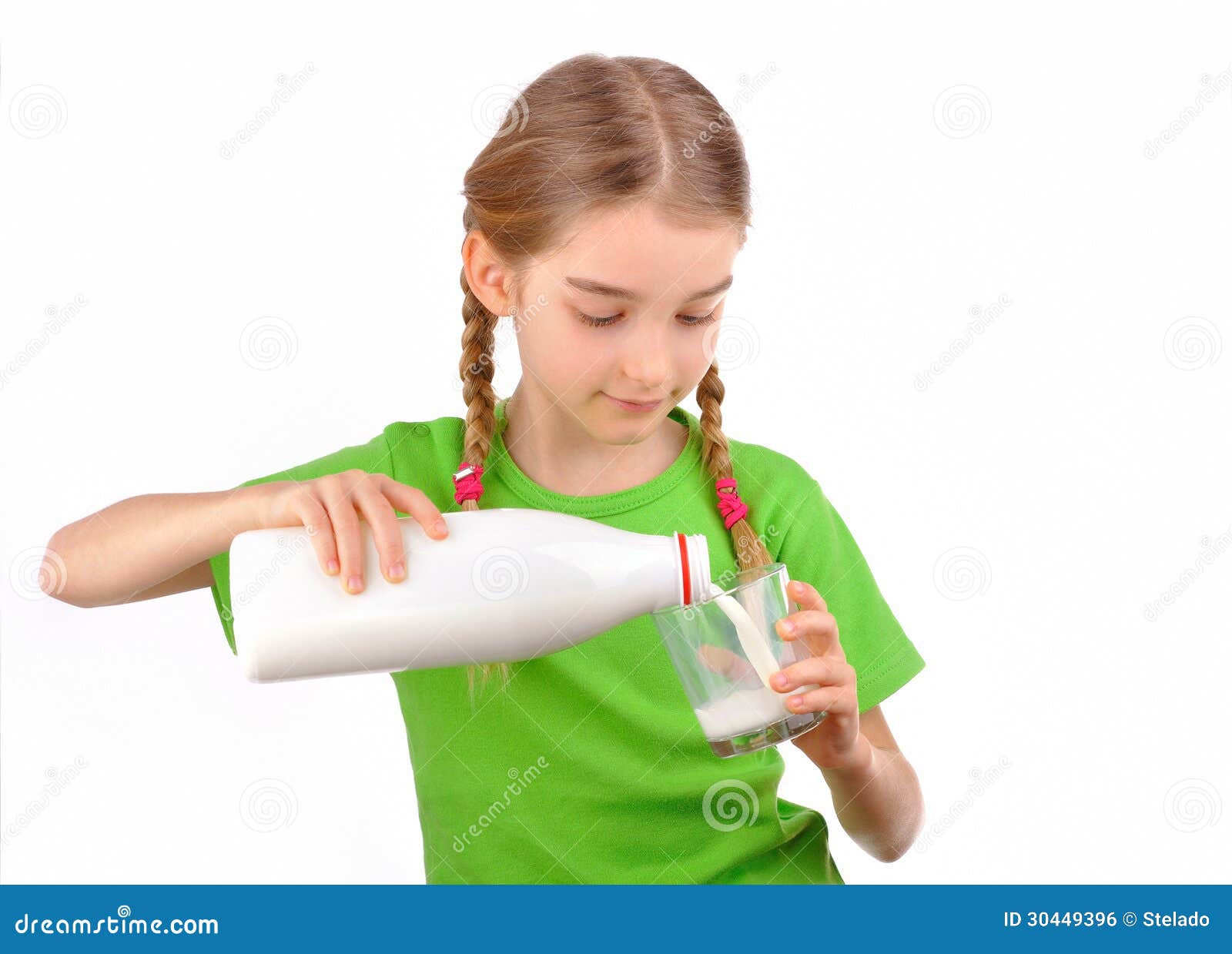 little girl pours milk from a bottle into glass