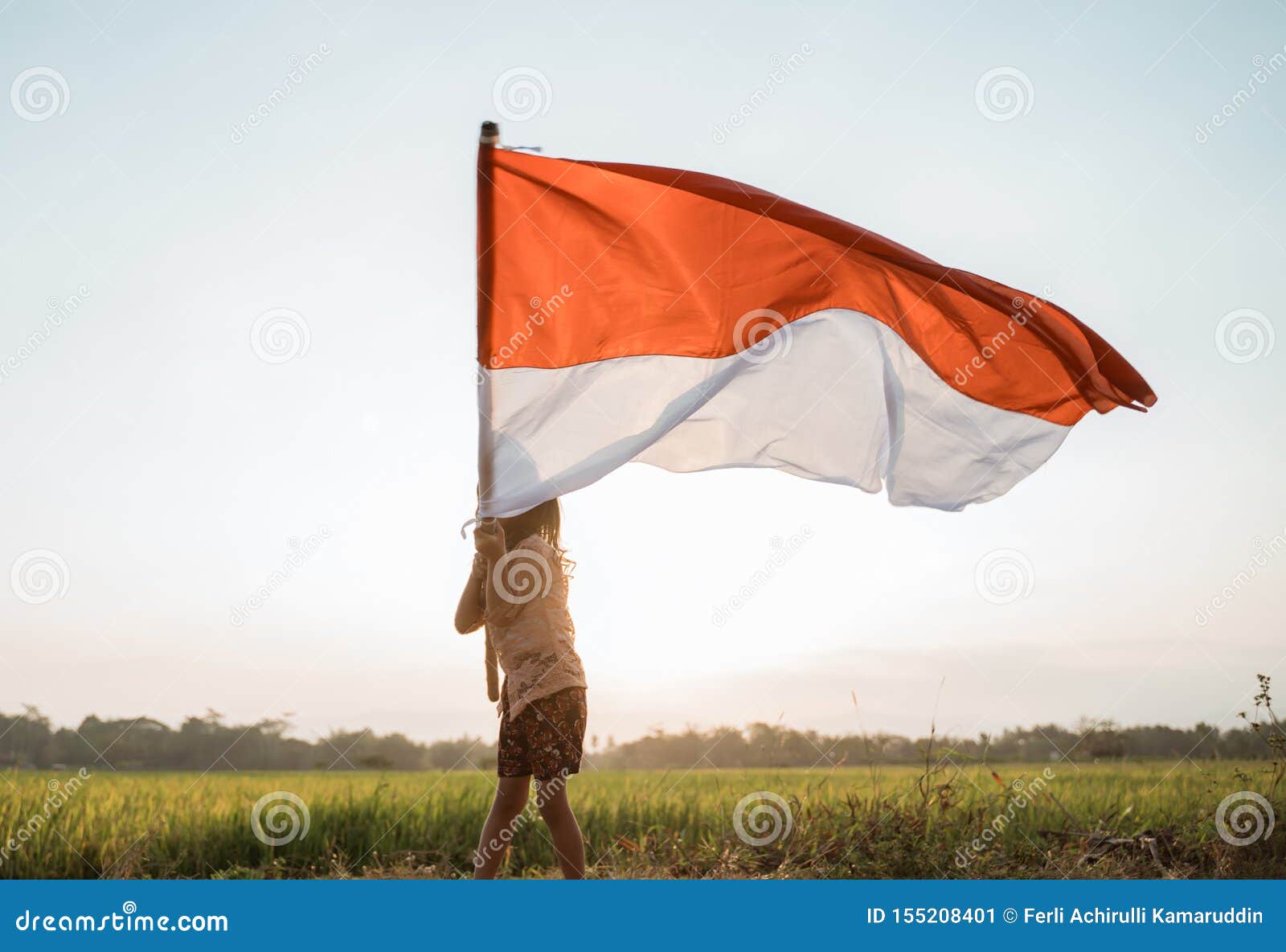 little girl pride flapping indonesian flag with happiness