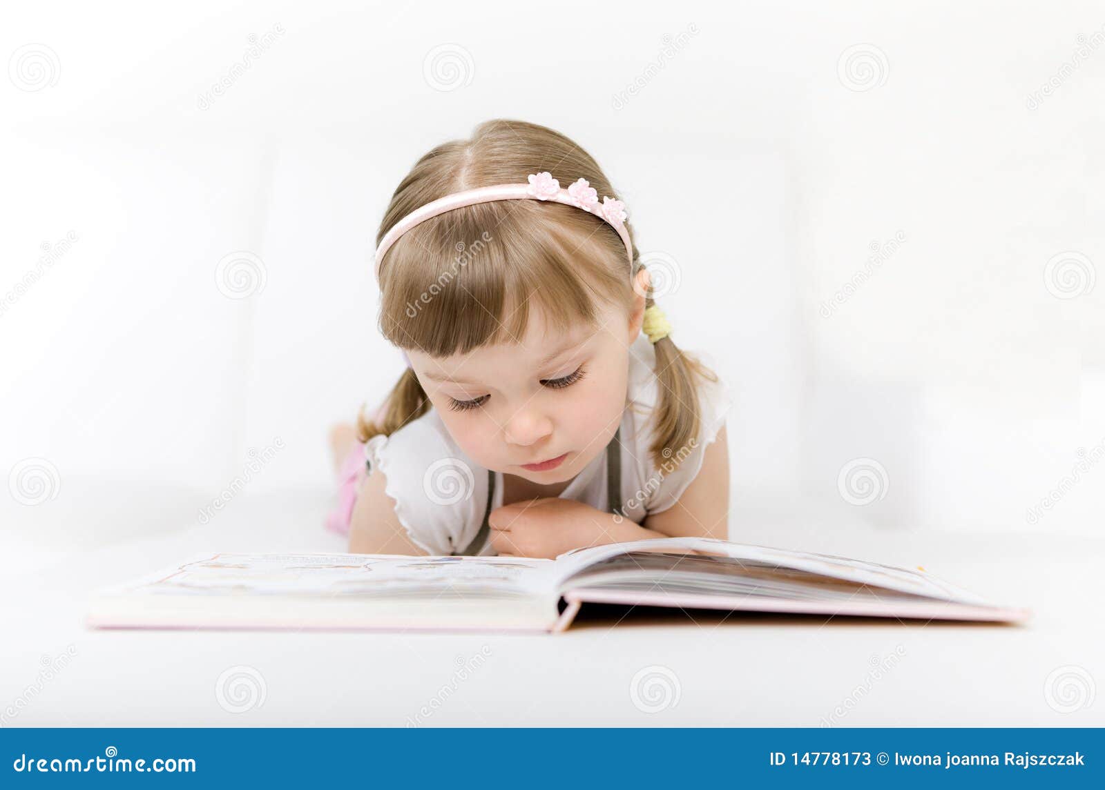 Sweet happy little girl reading book