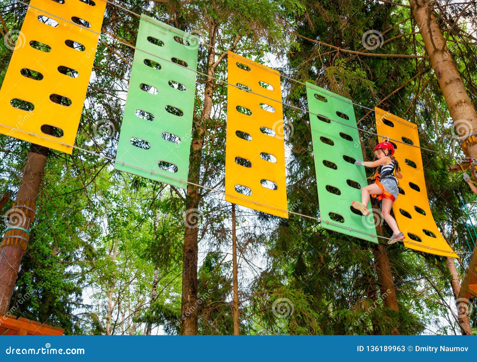 Little Girl On A Ropes Course In A Treetop Adventure Park 