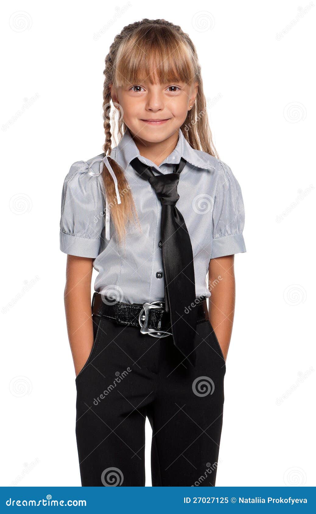 Happy little girl in school uniform with hands in pockets isolated on white background