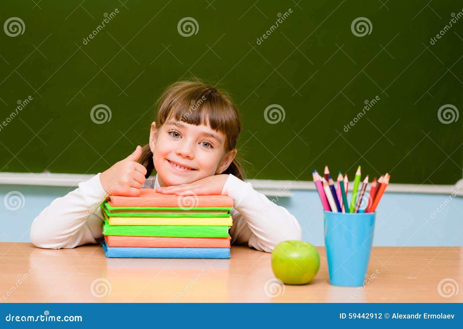 little girl showing thums up on the background of chalkboard