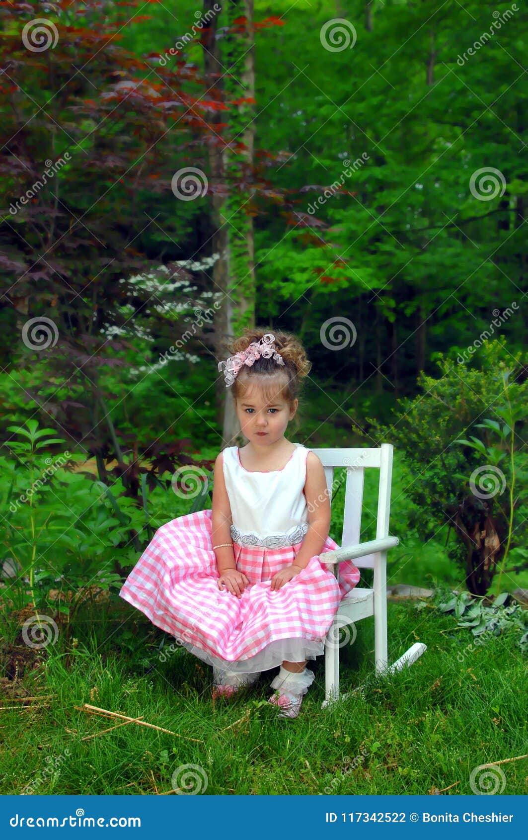 https://thumbs.dreamstime.com/z/little-girl-sits-grimace-her-face-not-feeling-like-giving-sunny-easter-smile-pink-gingham-dress-curly-bow-makes-117342522.jpg
