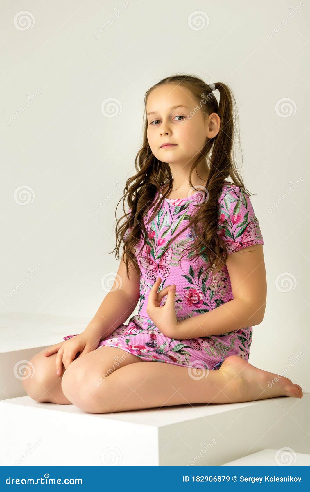 Little Girl Sitting on a White Cube Cross-legged. Stock Image - Image ...