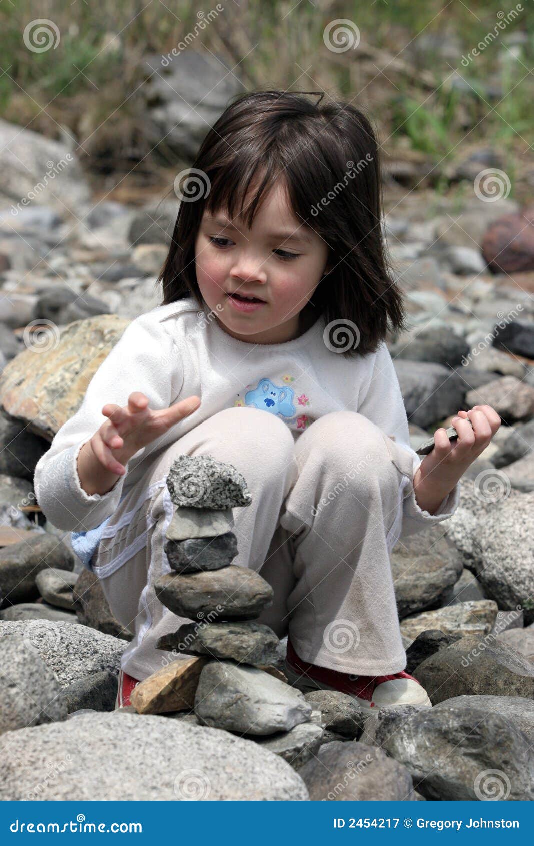 Little girl stacks rocks stock image. Image of beautiful 2454217