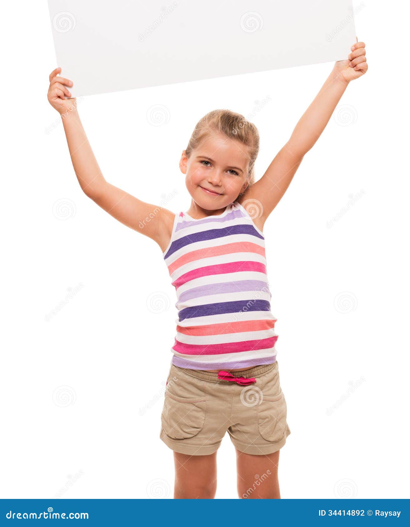 Little girl is standing on white background and holding white ca. I can hold this piece of cardboard where could be your advertisement or logo of your company