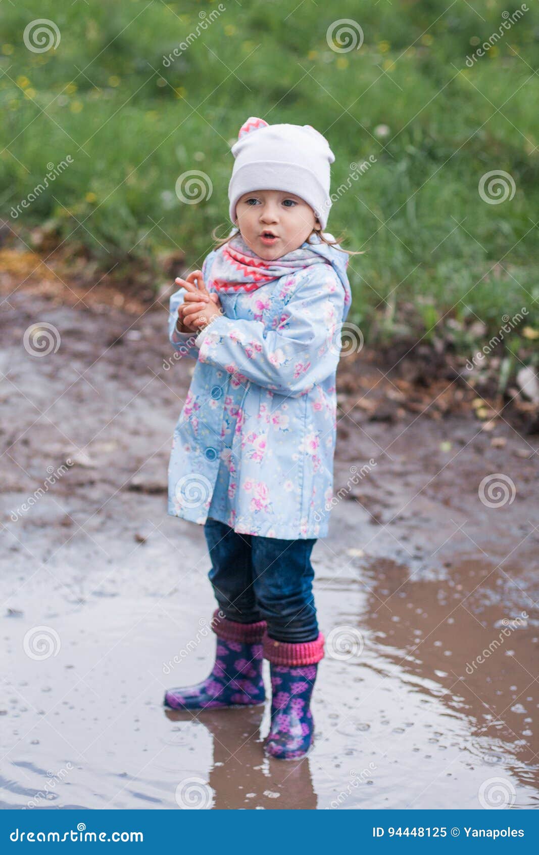 Little Girl Staying in the Puddle and Looking at the Left Stock Image ...