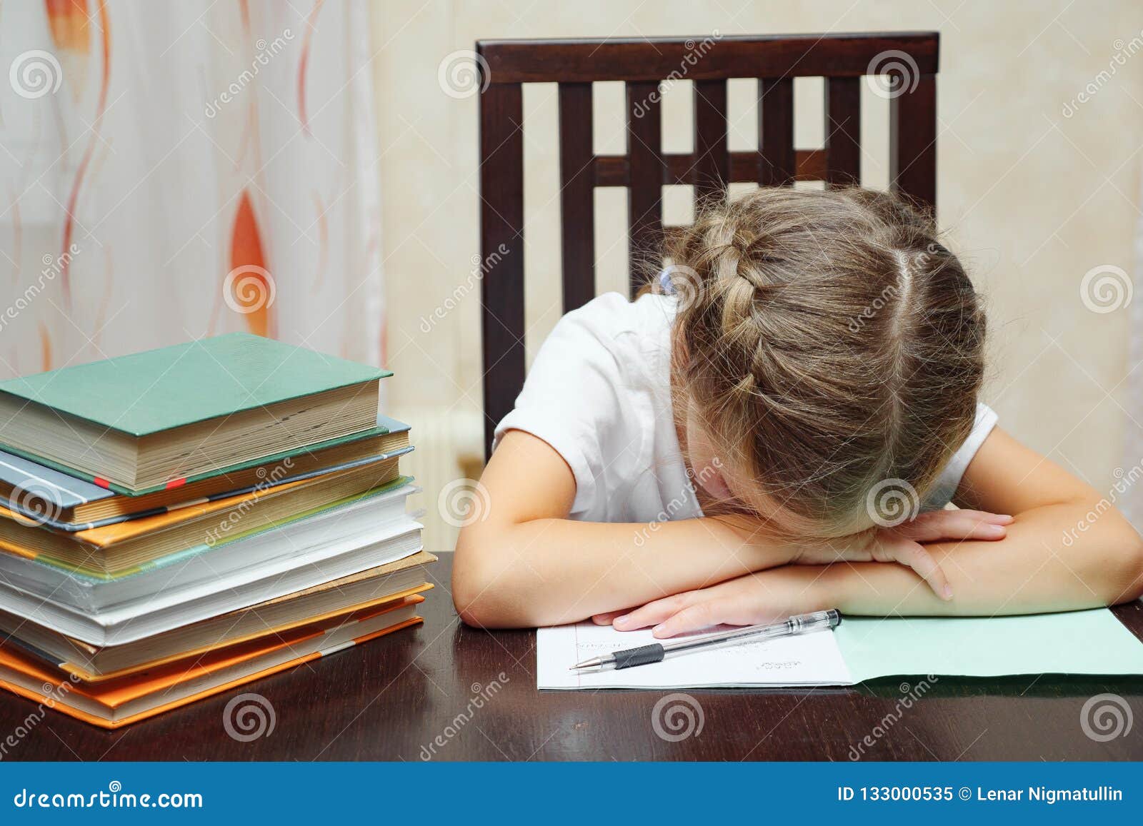 Little girl with textbooks studying asleep at the table