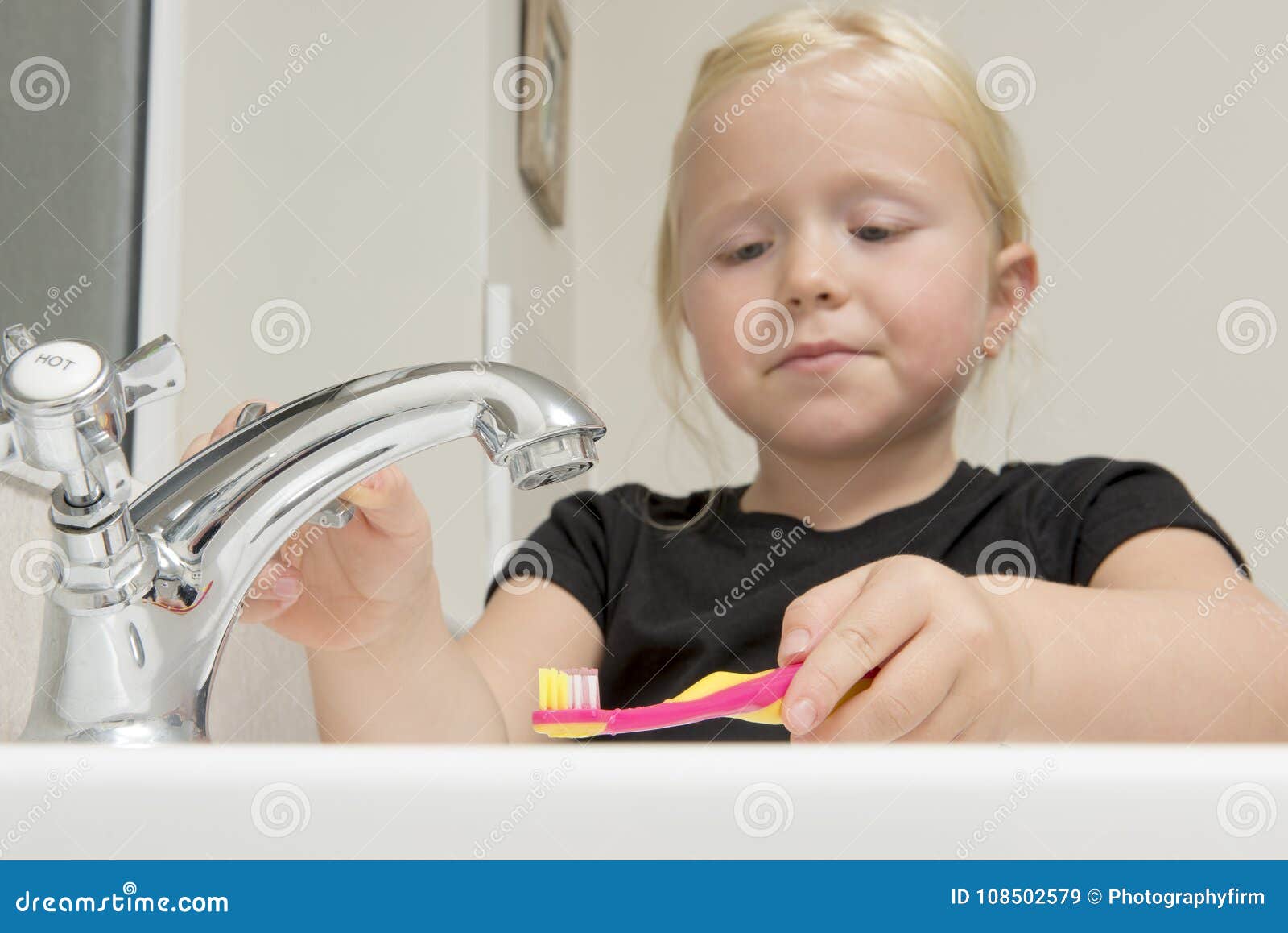 girl washing bat in bathroom sink