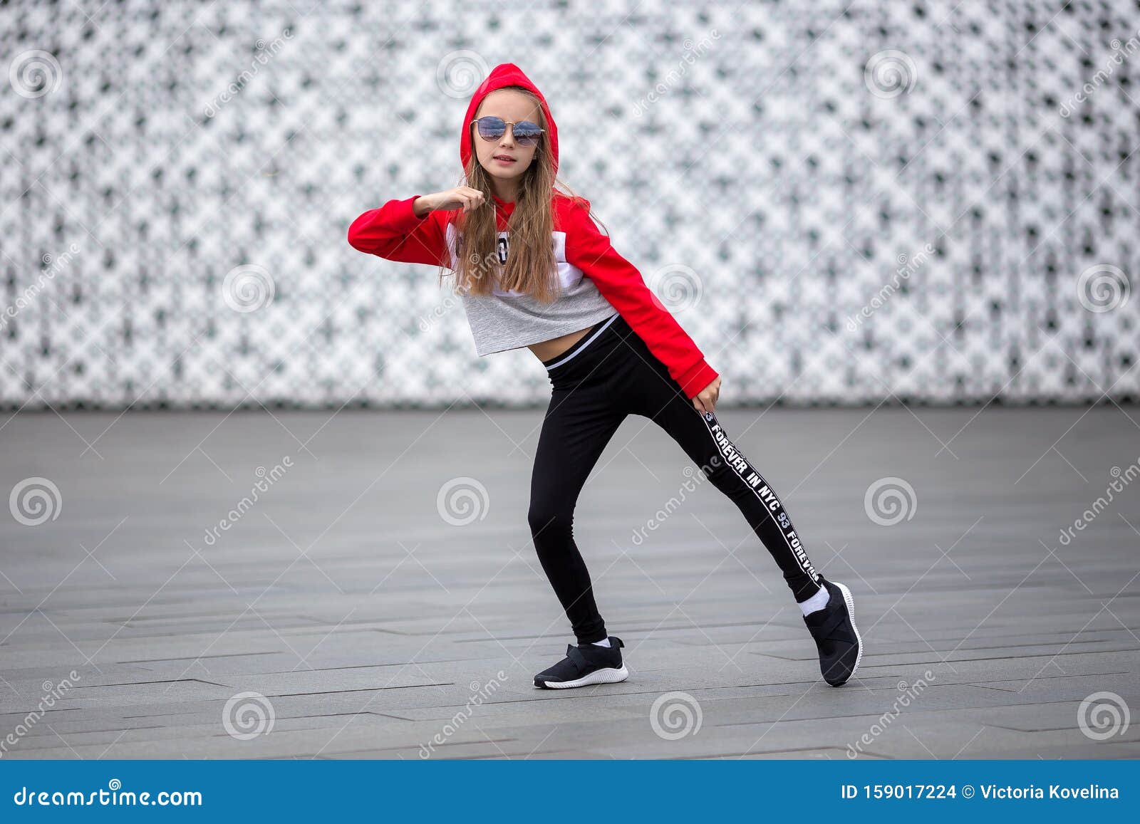 Little Girl In A Tracksuit Is Dancing Modern Dance On The Street