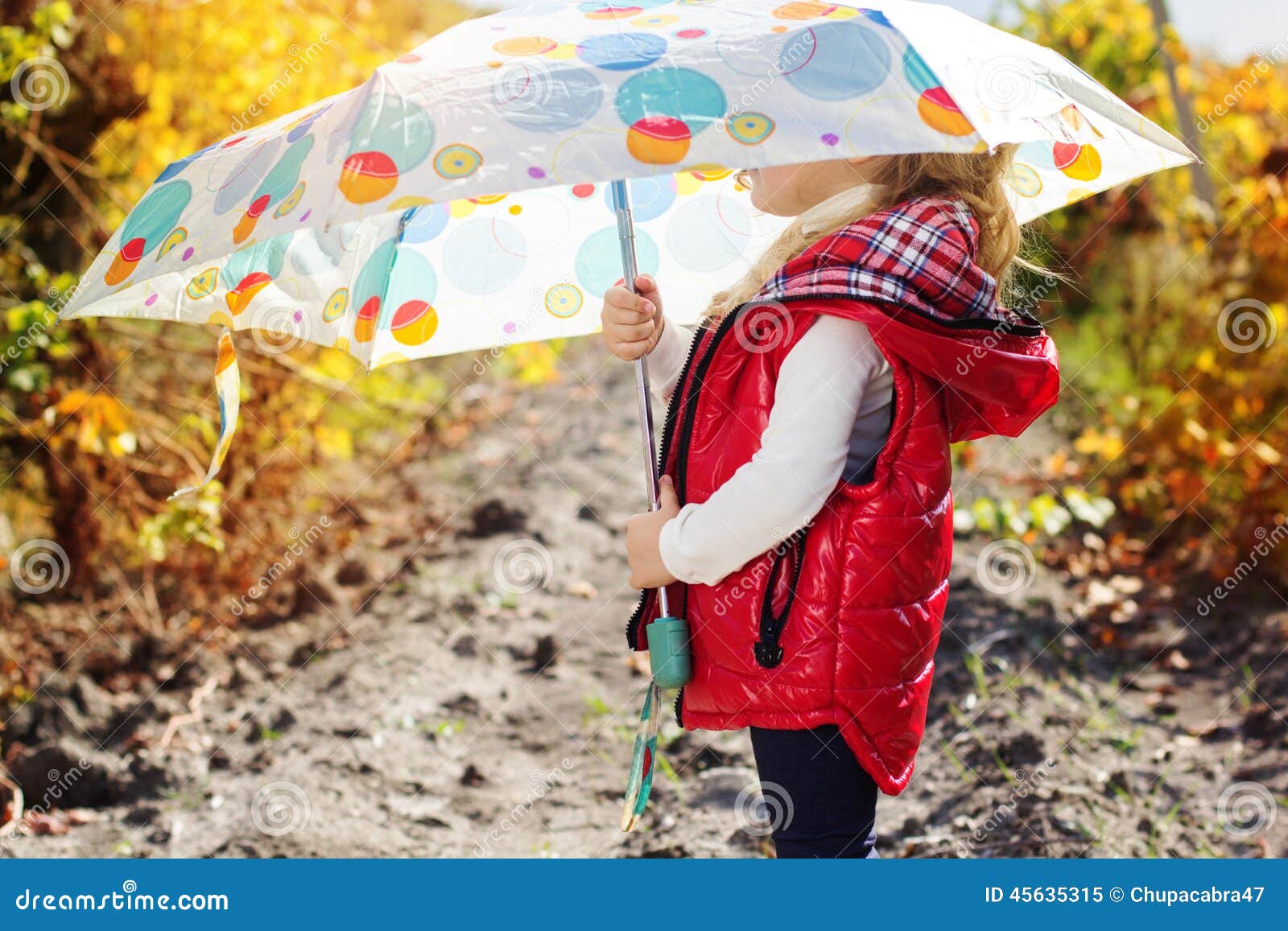 Little girl with umbrella in red vest outdoor. Smiling little girl with white umbrella is wearing red vest and boots outdoor