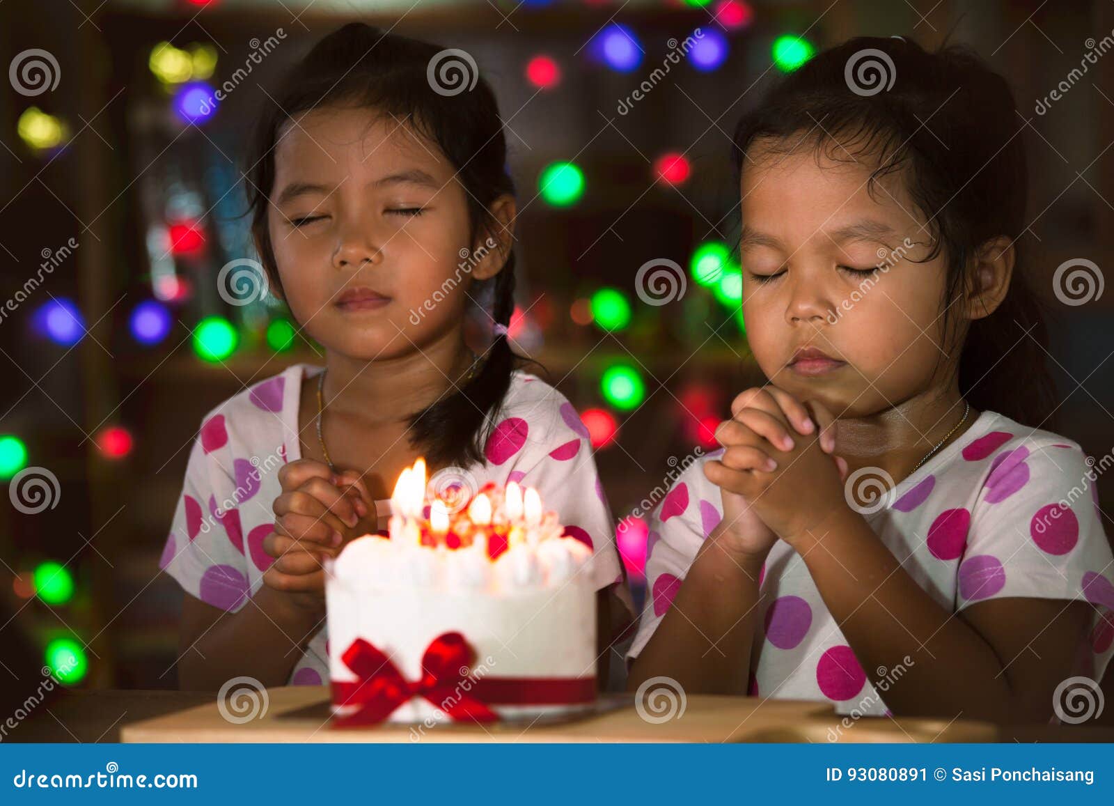 little girls make folded hand to wish the good things for their birthday
